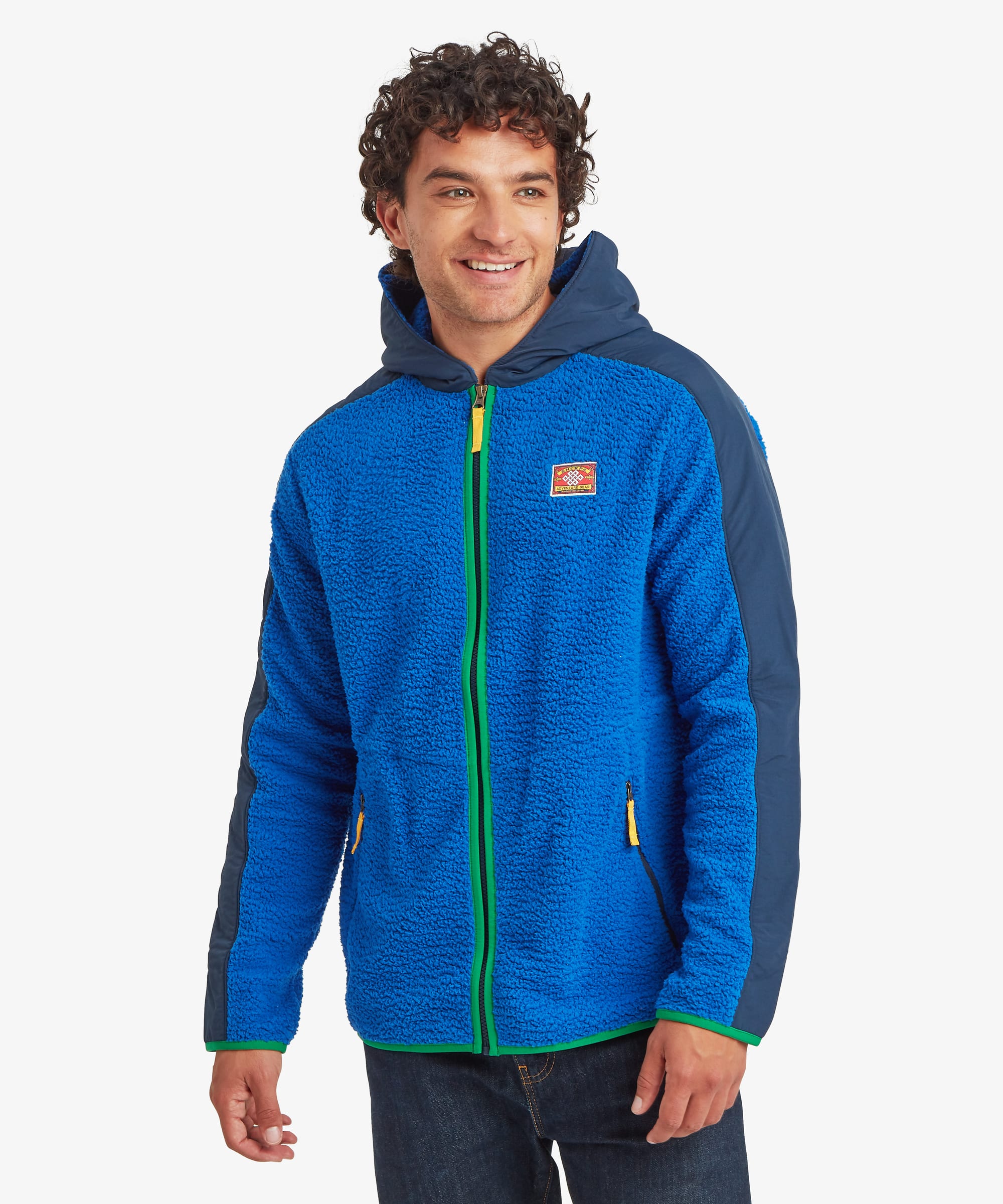 A male model wearing the Sherpa Men's Tarcho Hooded Jacket in blue, front view with hood down against a white studio background.