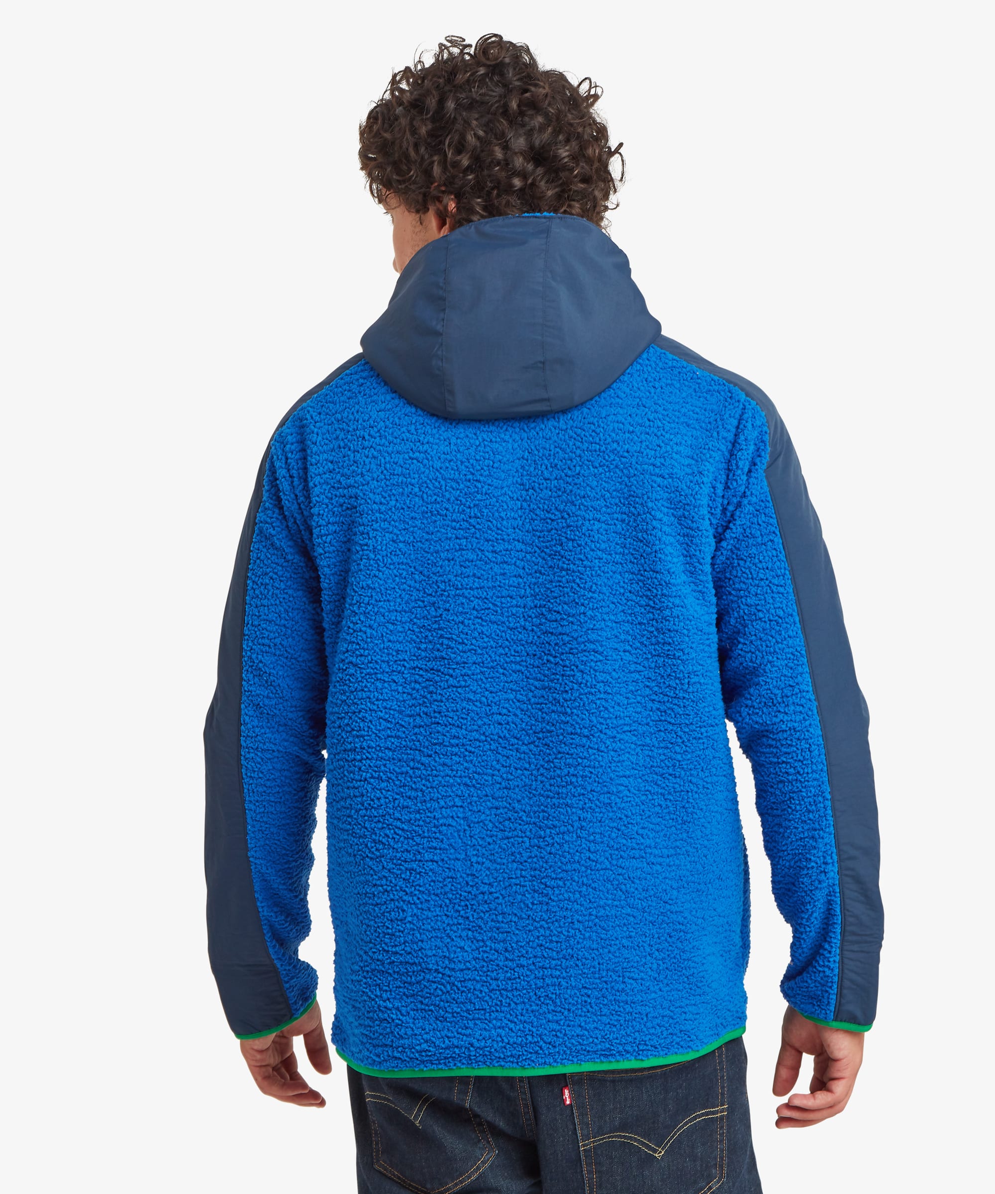 Rear view of a male model wearing the blue Sherpa Tarcho Hooded Jacket, showing the contrasting hood, textured fleece back and relaxed fit.