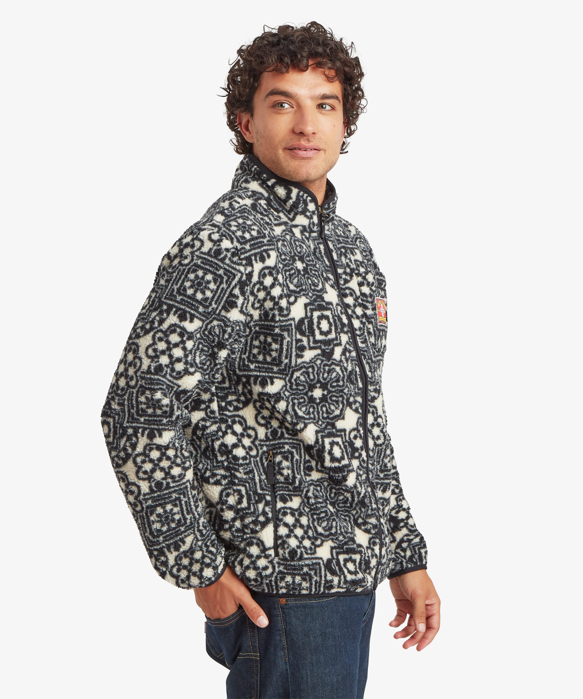 Side view of a black printed full-zip fleece jacket featuring an allover geometric pattern. Designed with a stand collar and relaxed fit.
