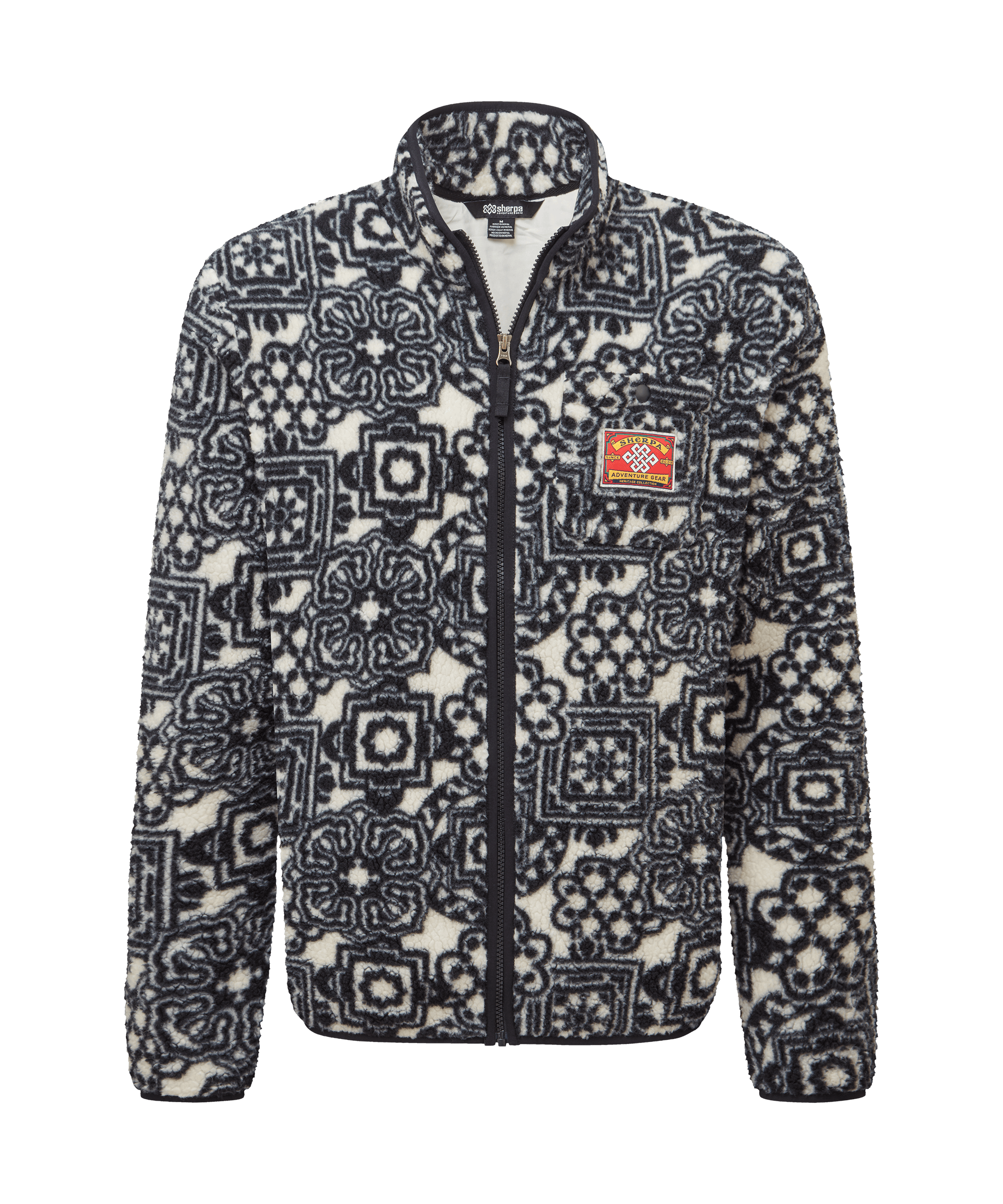 Front view of a men's Sherpa Adventure Gear black full-zip fleece jacket displayed on a white background. Features an all-over geometric print inspired by Himalayan textiles, a stand collar, chest patch detail, and a plush fleece texture.