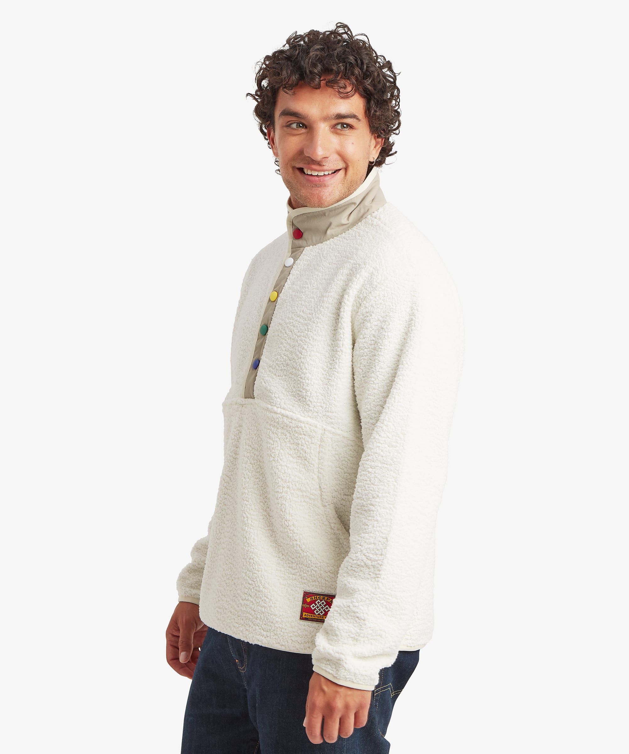 Side profile of a male model wearing the Sherpa Tarcho Snap Pullover in white, showing the relaxed fit, high stand collar, long sleeves and textured fleece construction.