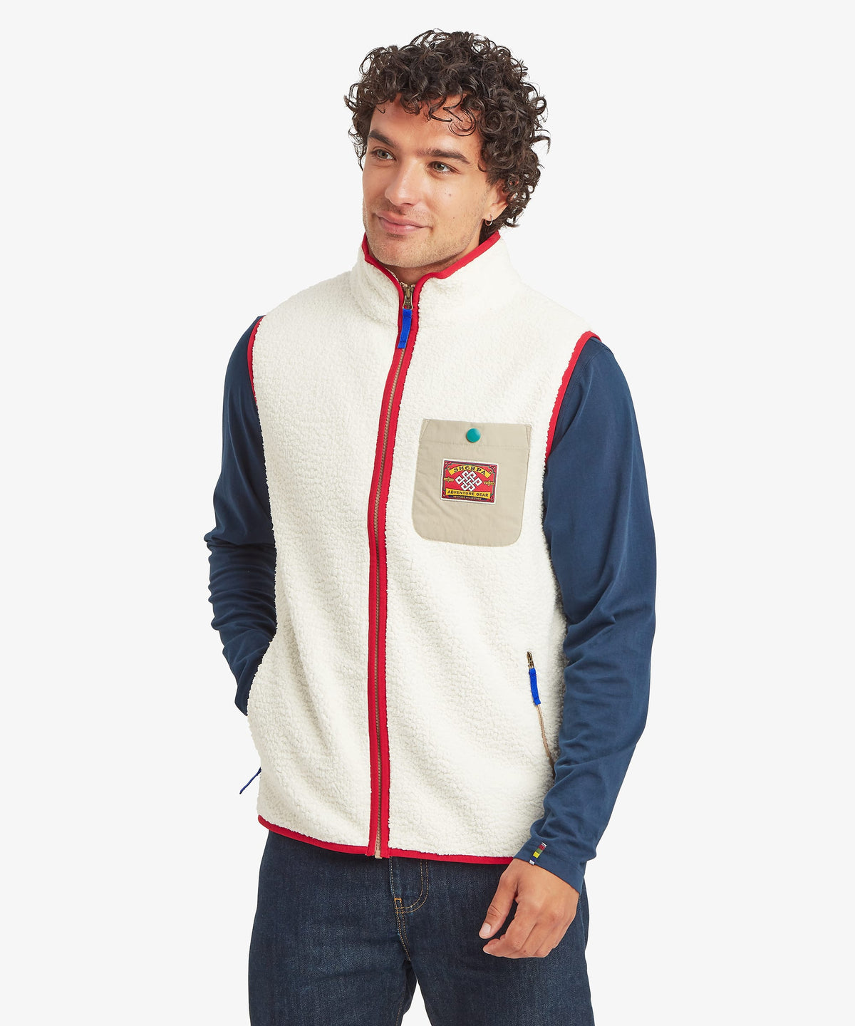 Front view of a male model wearing the Sherpa Tarcho Vest in white fleece with red trim.