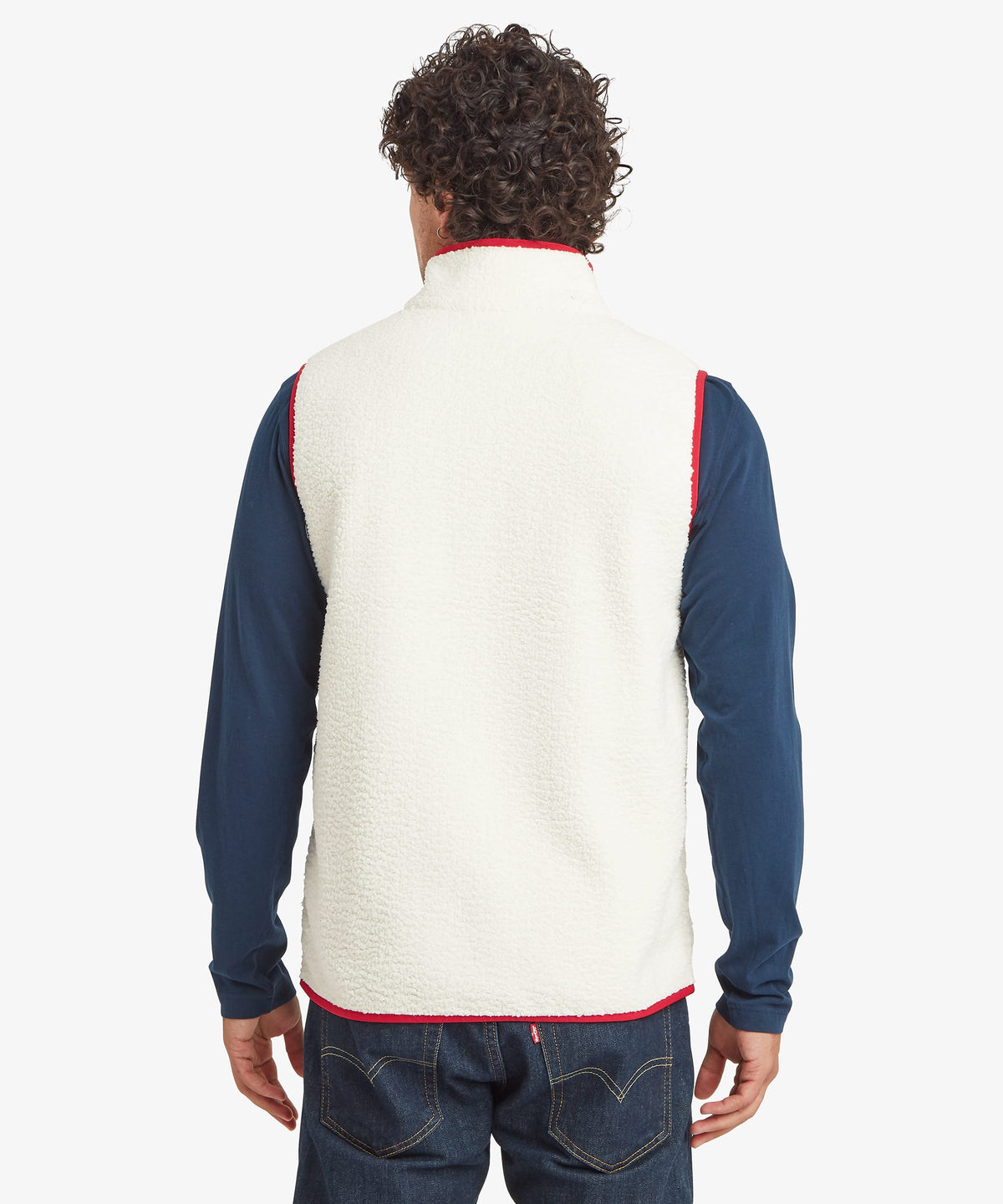 A man viewed from the back wearing a cream Sherpa Adventure Gear fleece vest over a navy blue.