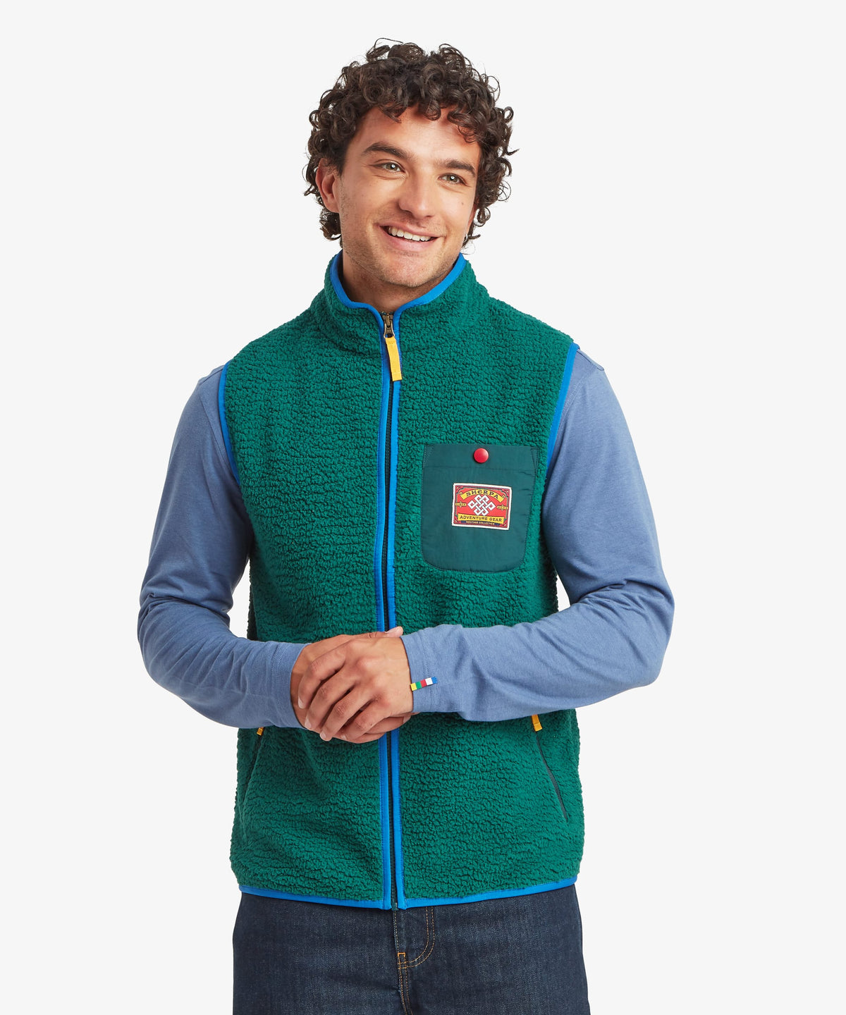 A smiling man wearing a green fleece vest over a light blue long-sleeve shirt.