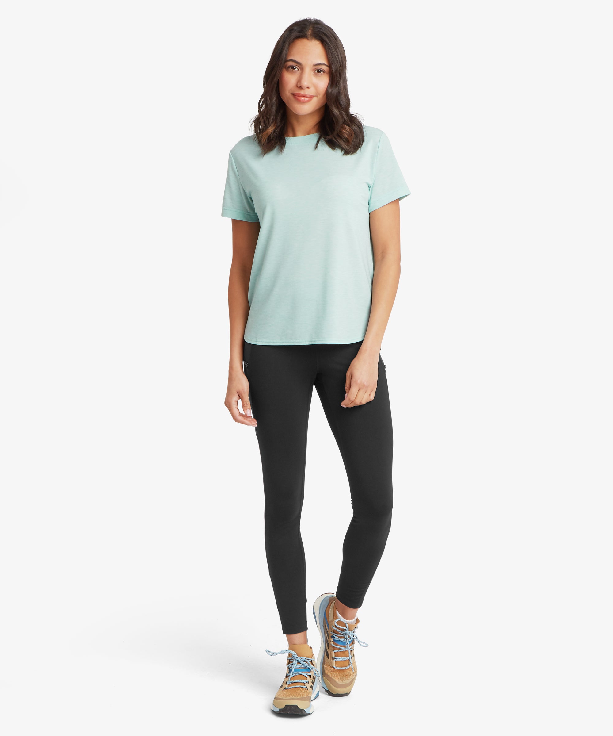 Ganzkšrperansicht eines hellaquafarbenen Performance-T-Shirts mit kurzen €rmeln, kombiniert mit schwarzen Leggings und Trail-Schuhen, das den lockeren Fall, den abgerundeten Saum und das weiche, atmungsaktive Material hervorhebt, das sich ideal fŸr aktive Outdoor-AktivitŠten eignet.