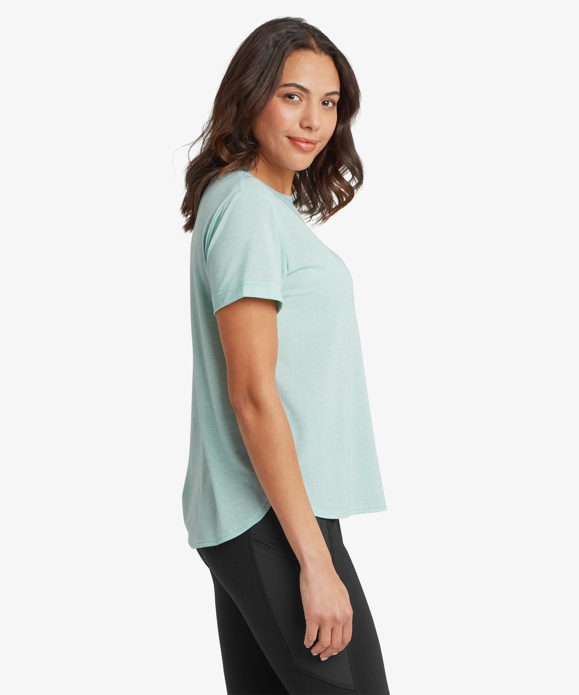 Frau in hellblauem T-Shirt und schwarzen Leggings vor wei§em Hintergrund. Die Frau steht seitlich und zeigt die LŠnge des Oberteils von vorne und hinten.