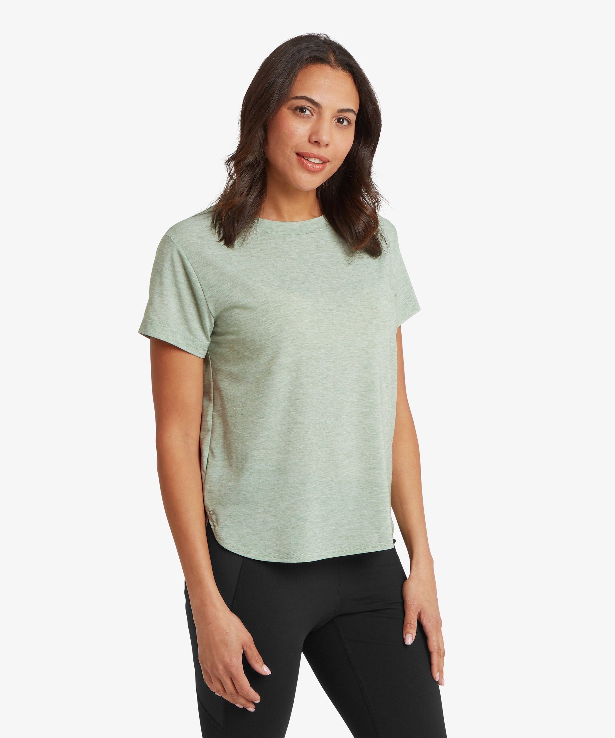 Woman wearing a light green t-shirt and black leggings on a white background