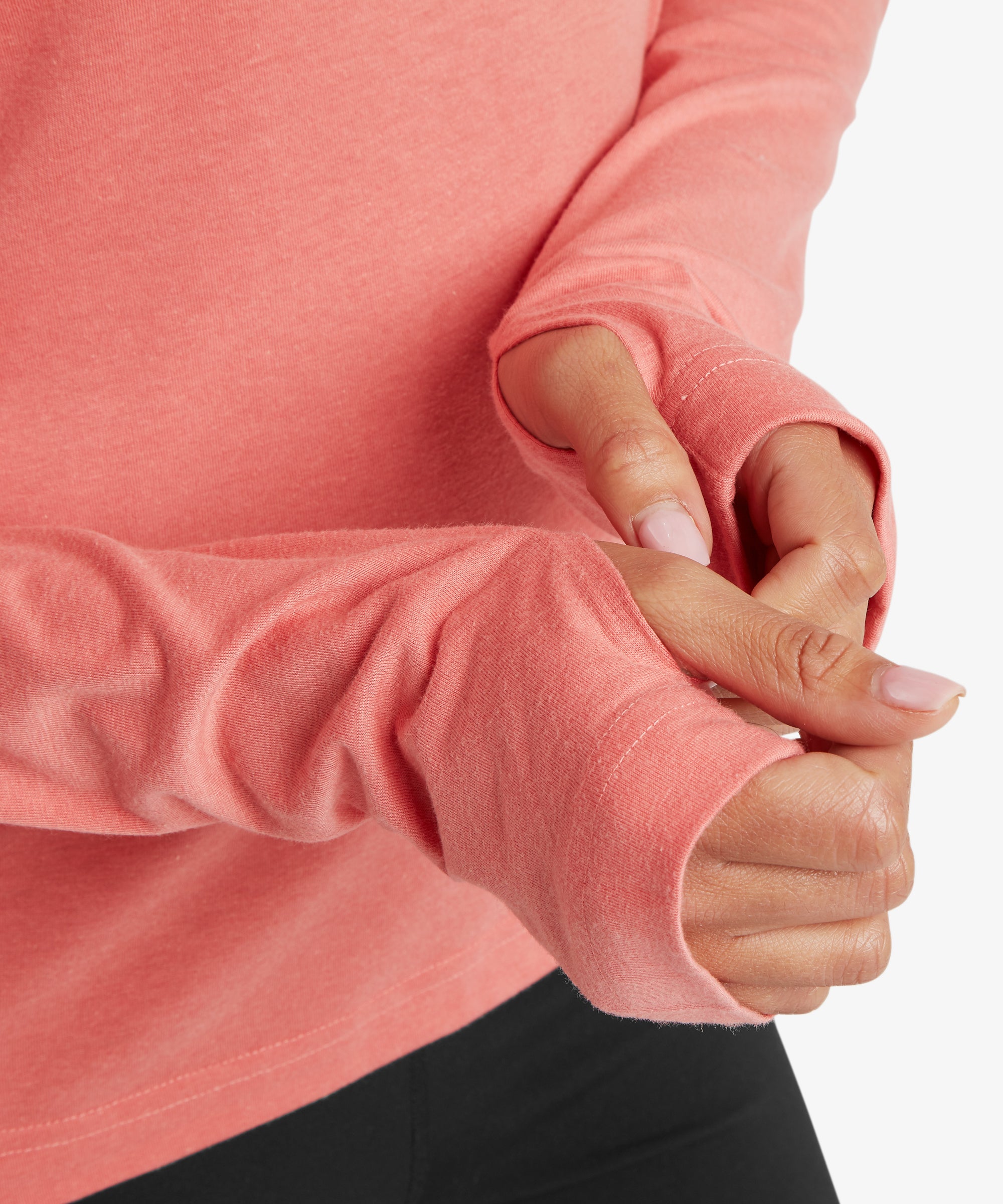 Close‑up of the Sherpa Bali Long‑Sleeve Tee sleeve cuffs in coral pink, showcasing the soft knit fabric and discreet thumbhole detail for added coverage and easy layering during cooler conditions.