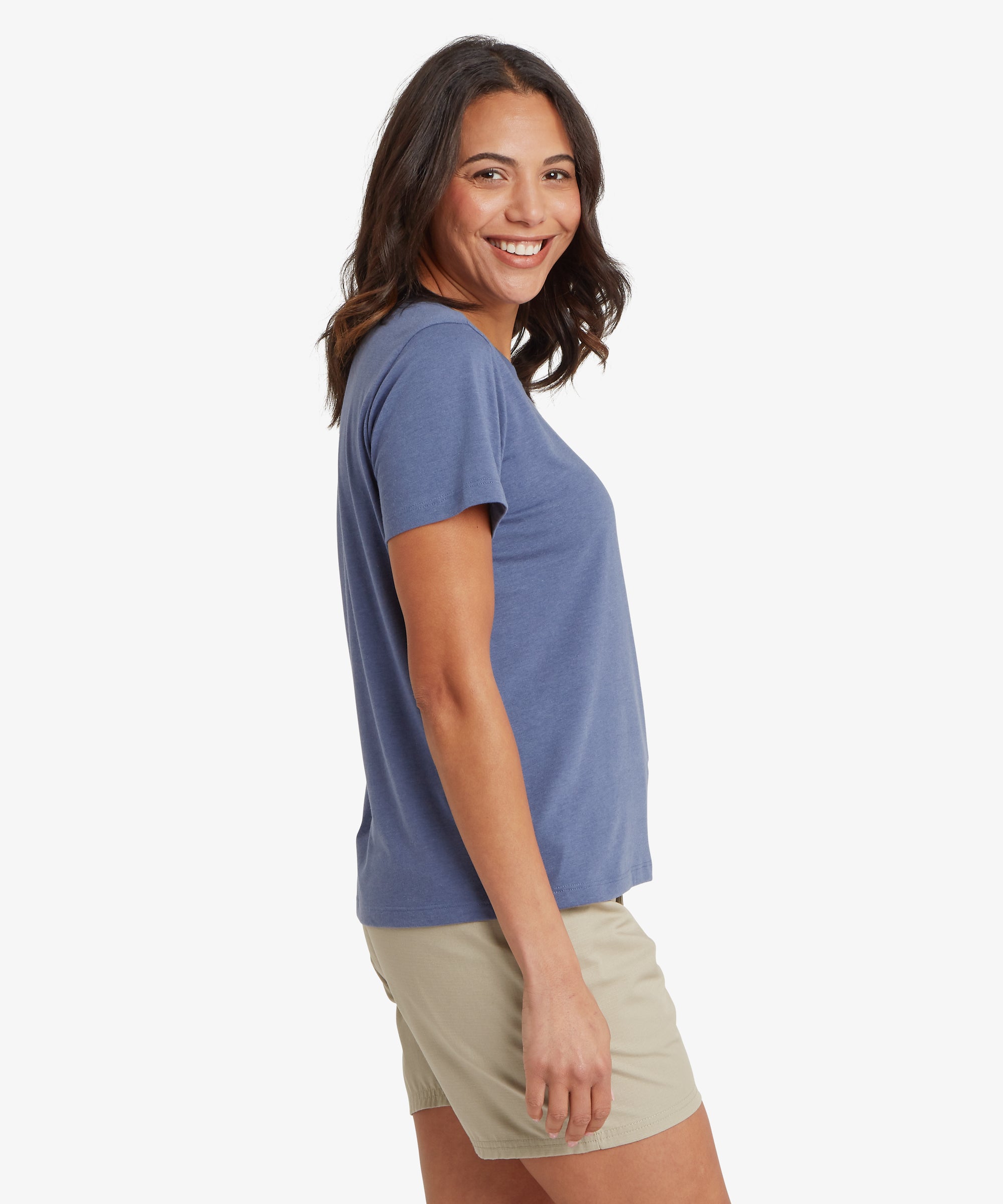 Side view of a slate blue short‑sleeve crew‑neck tee paired with light beige outdoor shorts, showing the relaxed silhouette, straight hemline, and smooth jersey fabric. The arm hangs naturally by the side, emphasising the casual fit and lightweight warm‑weather styling suitable for travel, walking, and everyday comfort.