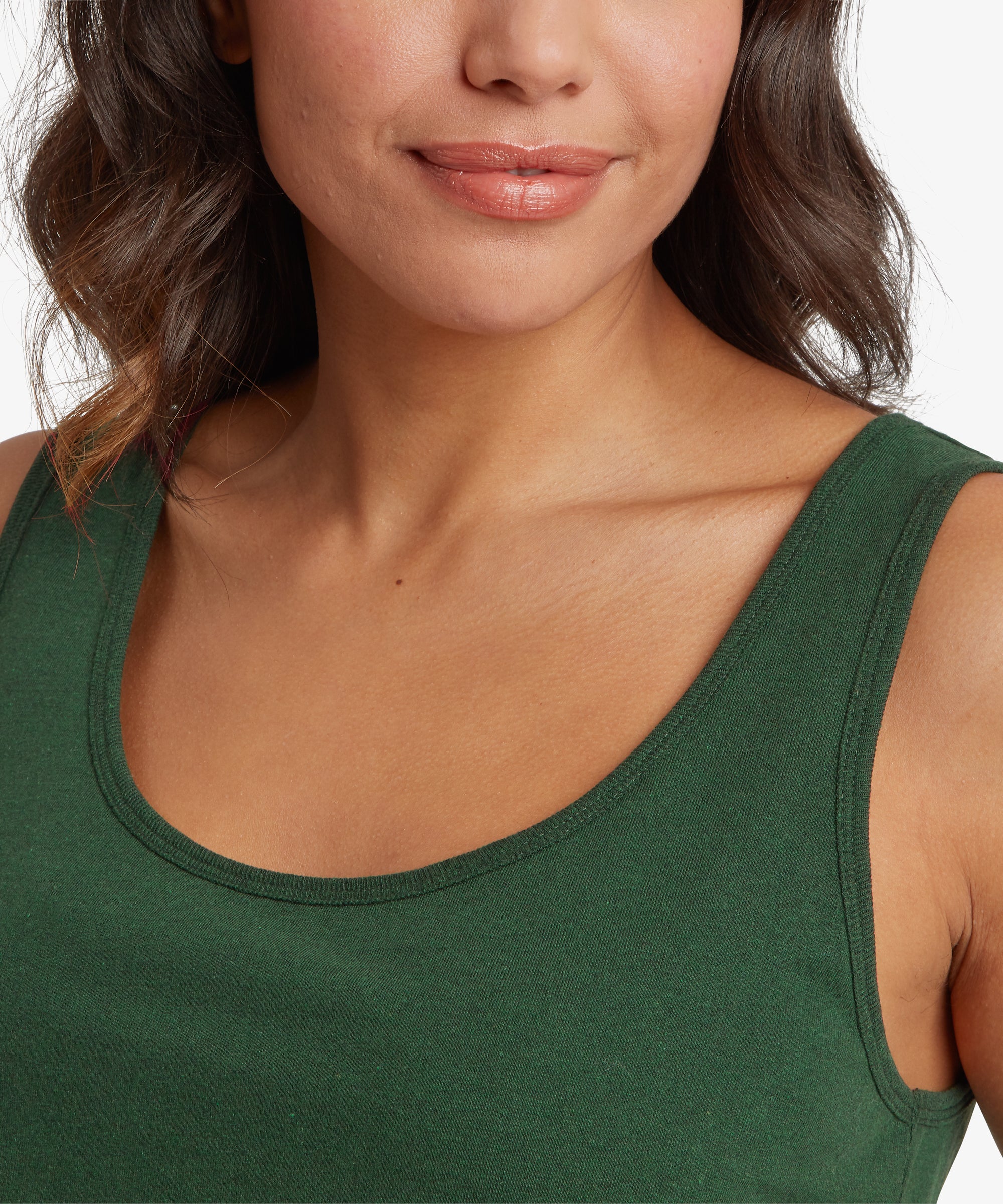Close-up of a person wearing a green tank top with a neutral background