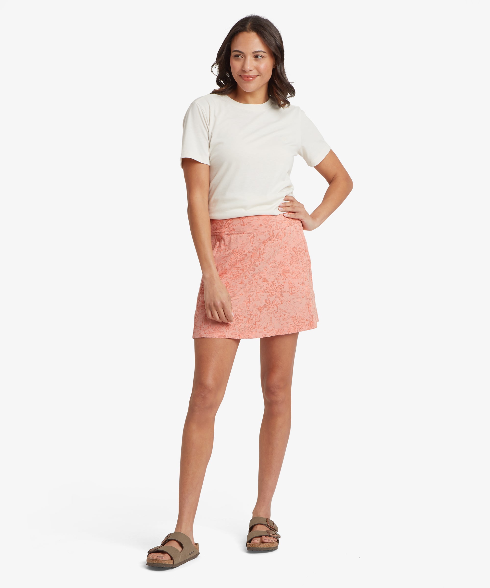 Woman wearing a white t-shirt and pink skirt on a white background