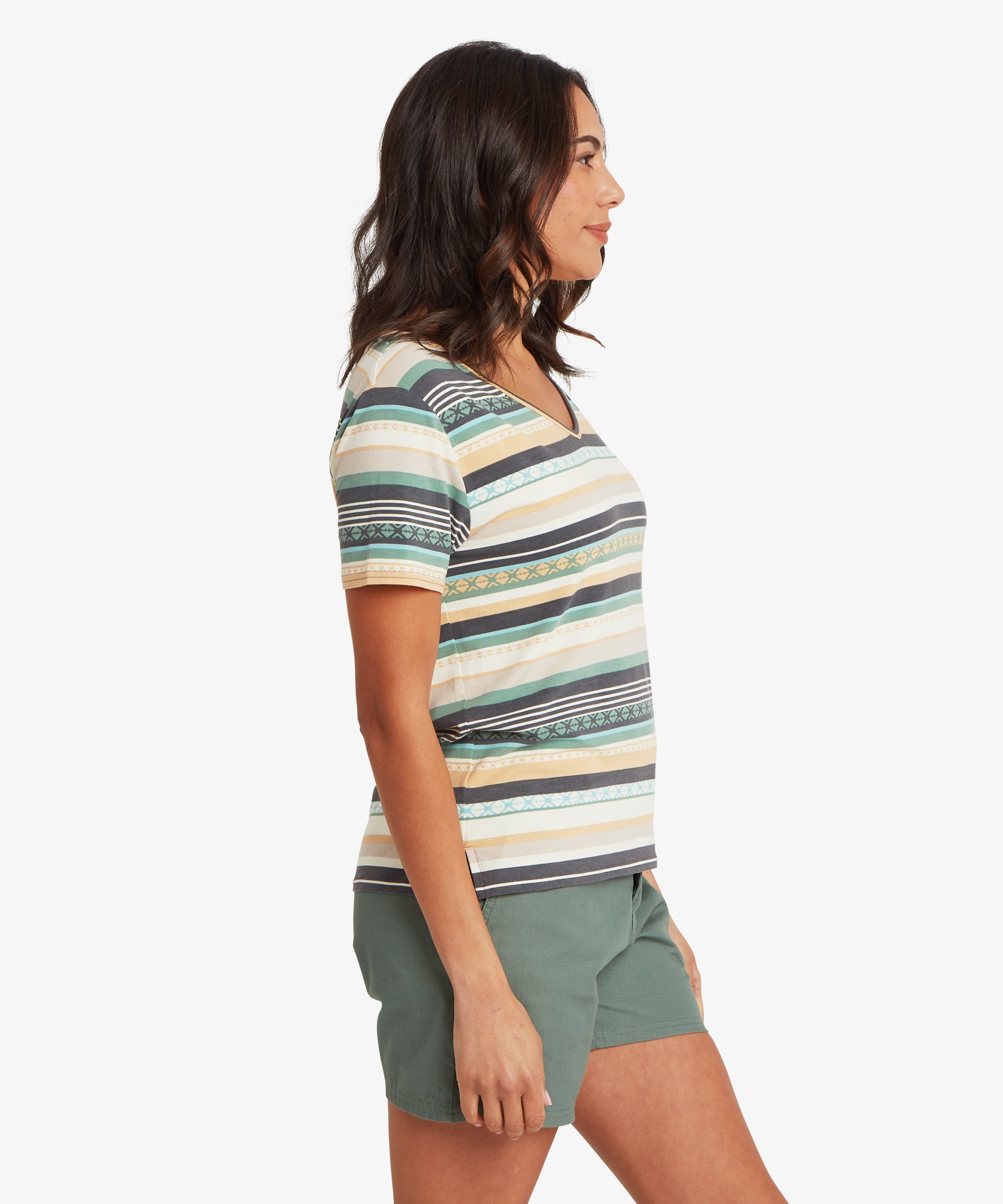 Side view of a woman wearing a striped V-neck T-shirt and olive green shorts, highlighting the straight side seam, short sleeves ending mid–upper arm, and relaxed silhouette; her head is turned slightly forward.