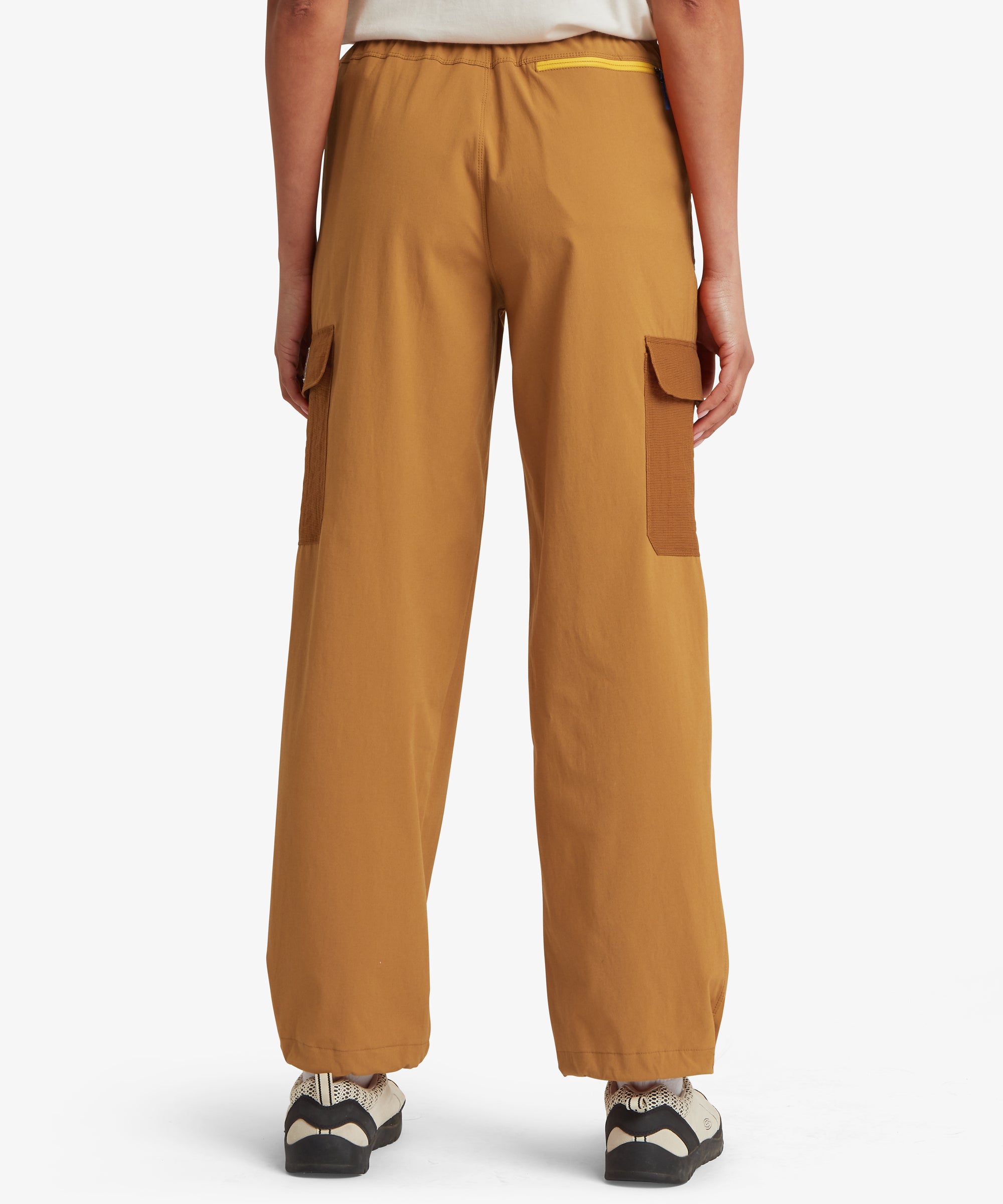 Back view of a woman wearing mustard-yellow trousers with a loose, straight-leg silhouette and elasticated waistband for a comfortable fit.