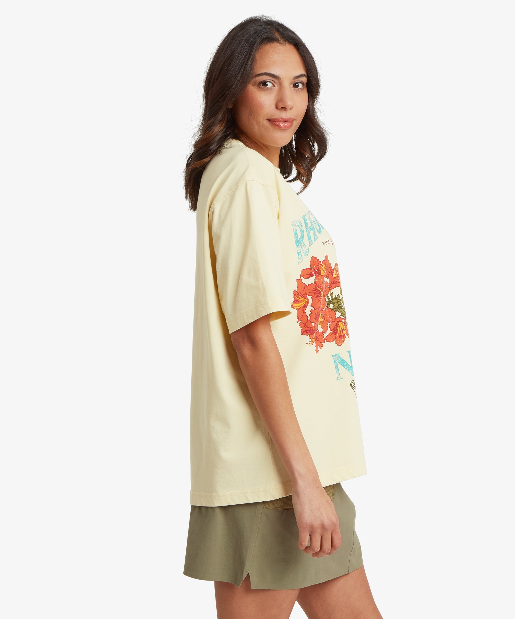 Seitenansicht einer Frau, die ein cremefarbenes T-Shirt mit Grafik, einer lockeren, kastenfšrmigen Silhouette und lŠngeren kurzen €rmeln trŠgt, das den Fall des Stoffes Ÿber dem Oberkšrper zeigt.