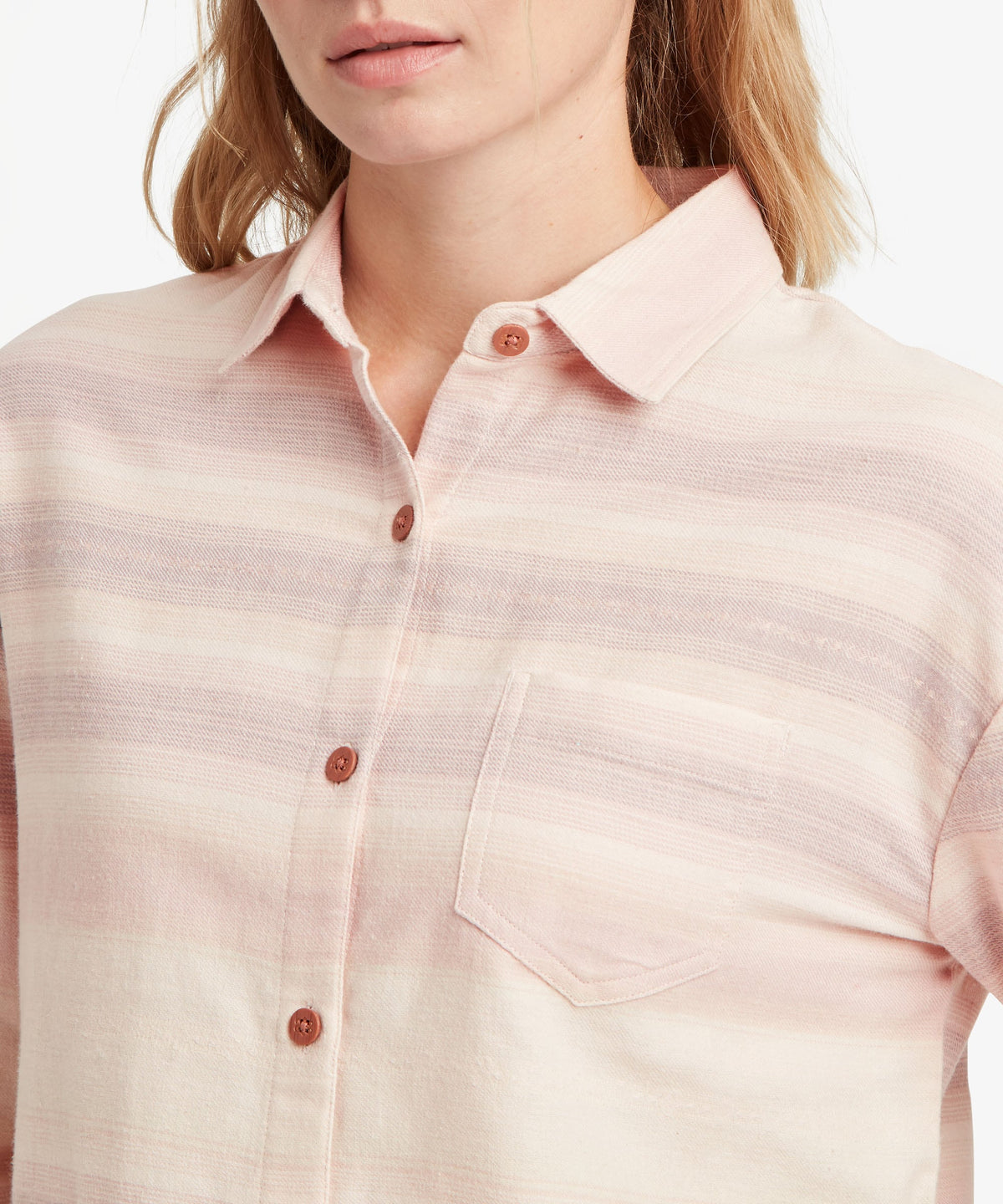Close-up of woman wearing Sherpa Adventure Gear Beeja Long Sleeve Shirt in beige.