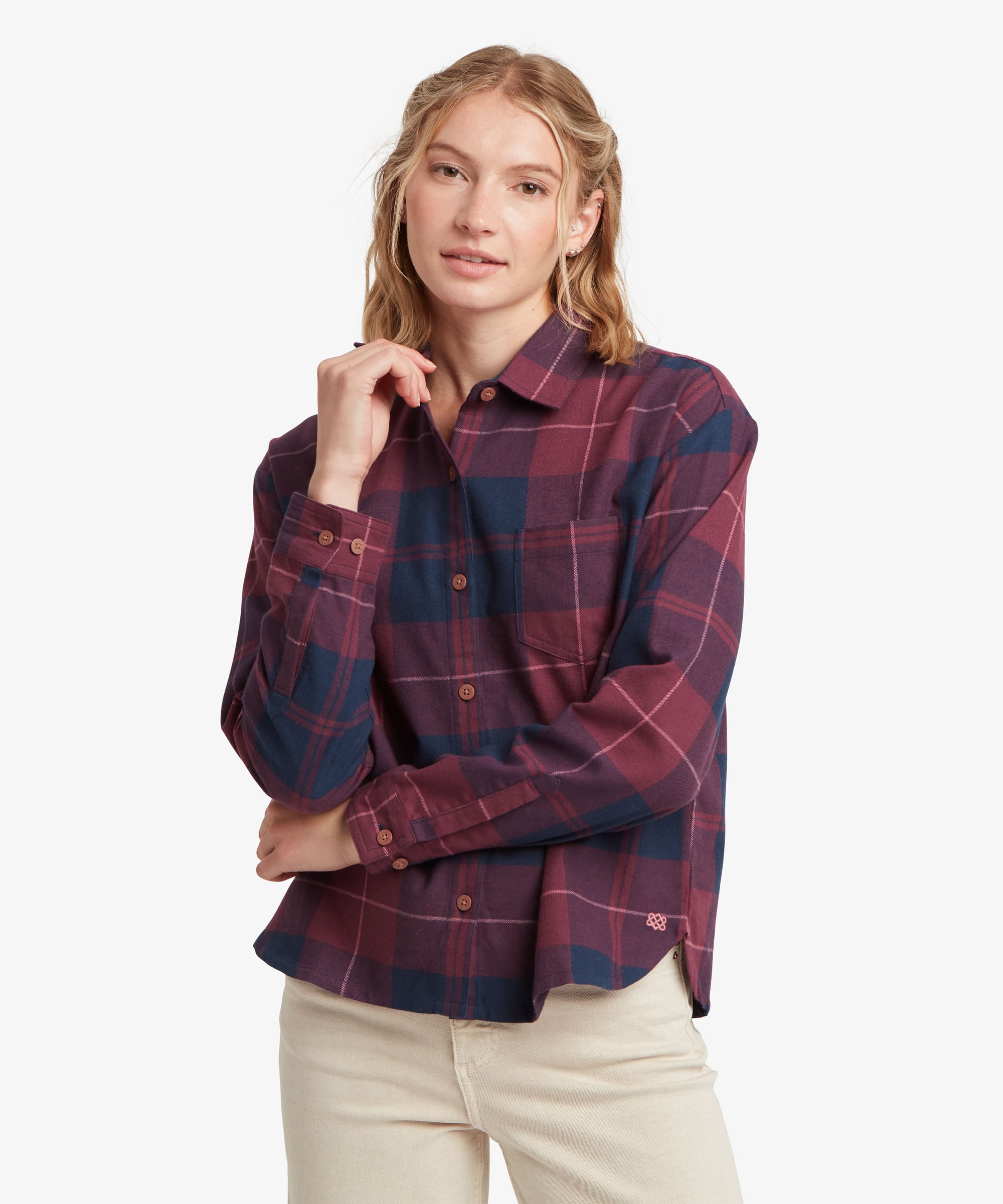 A female model standing against a plain white studio background wearing the Sherpa Adventure Gear Beeja Long Sleeve Shirt in purple and navy check, shown from the front. The shirt features a pointed collar, full button-through fastening, long sleeves with button cuffs and an all-over checked pattern combining purple, navy and red tones.