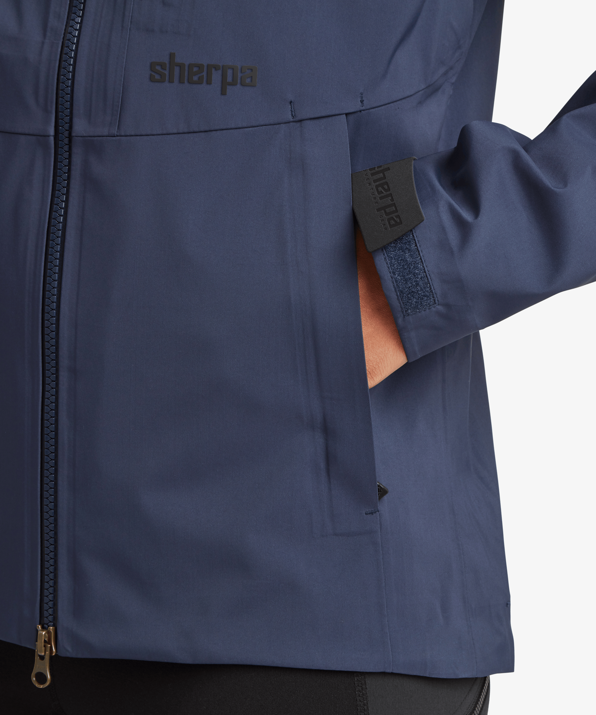 Detail view of the Women's Beyul 3-layer jacket in blue showing the zippered hand pocket and waterproof shell fabric.