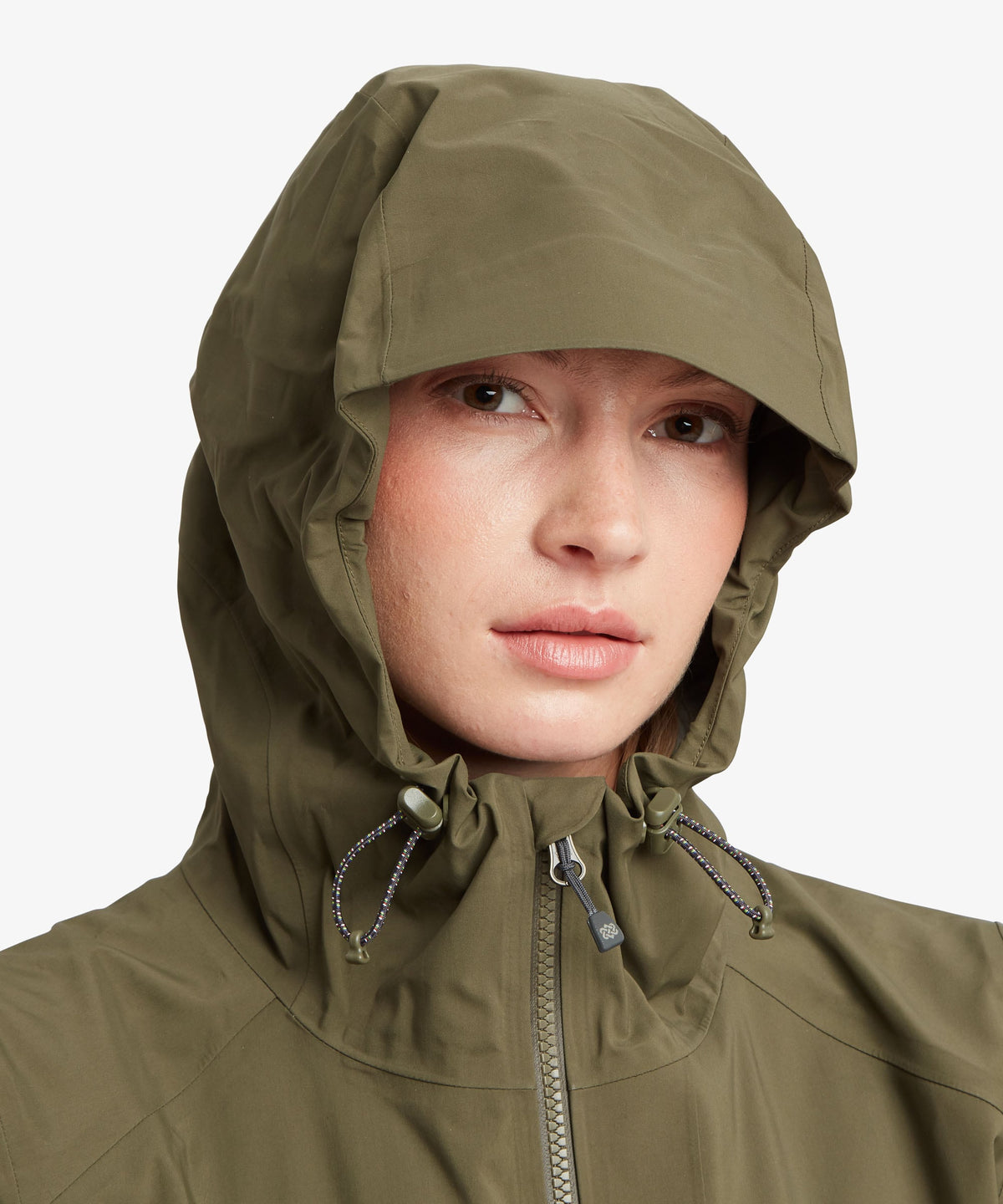 Close-up of a female model wearing an olive green hooded rain jacket against a light gray.