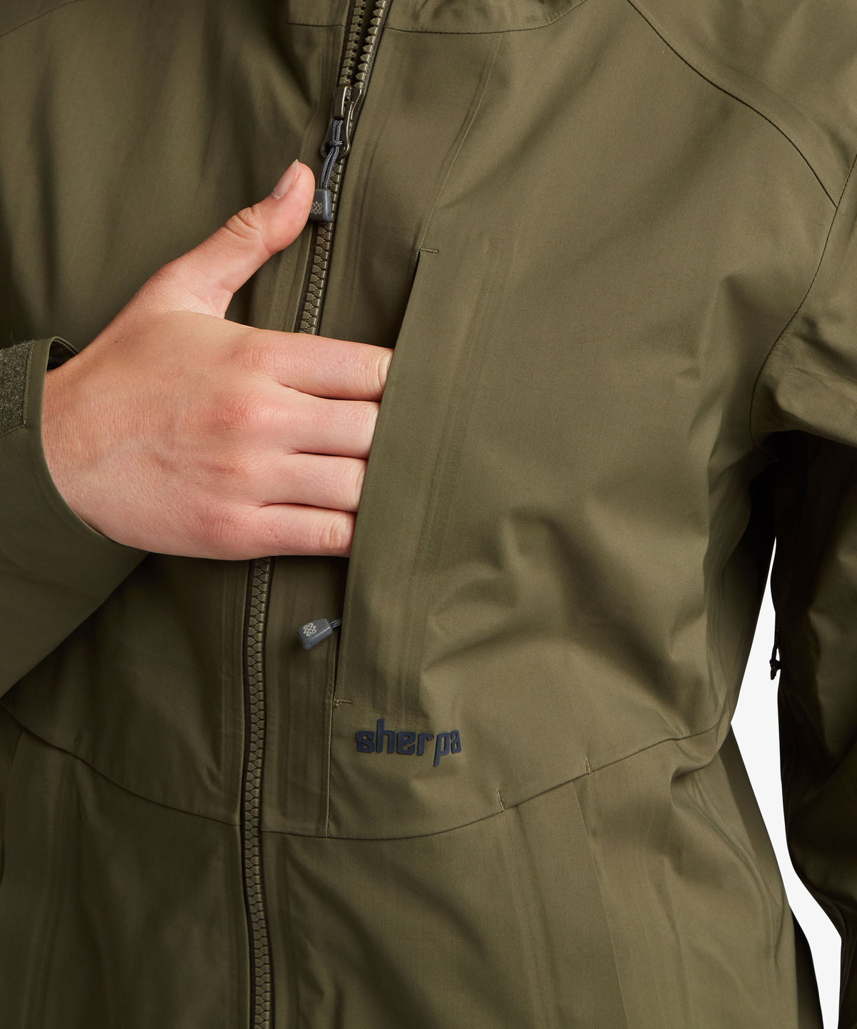 Close-up of woman wearing Sherpa Adventure Gear Beyul 3L Jacket in green.