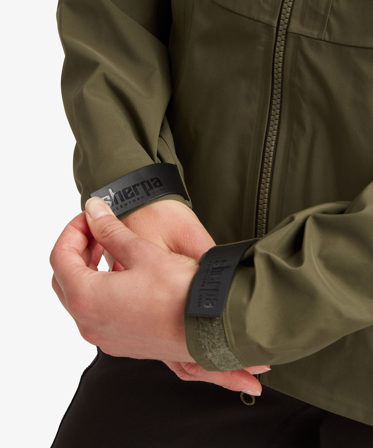 A female model wearing the Sherpa Adventure Gear Beyul 3L Jacket in green.