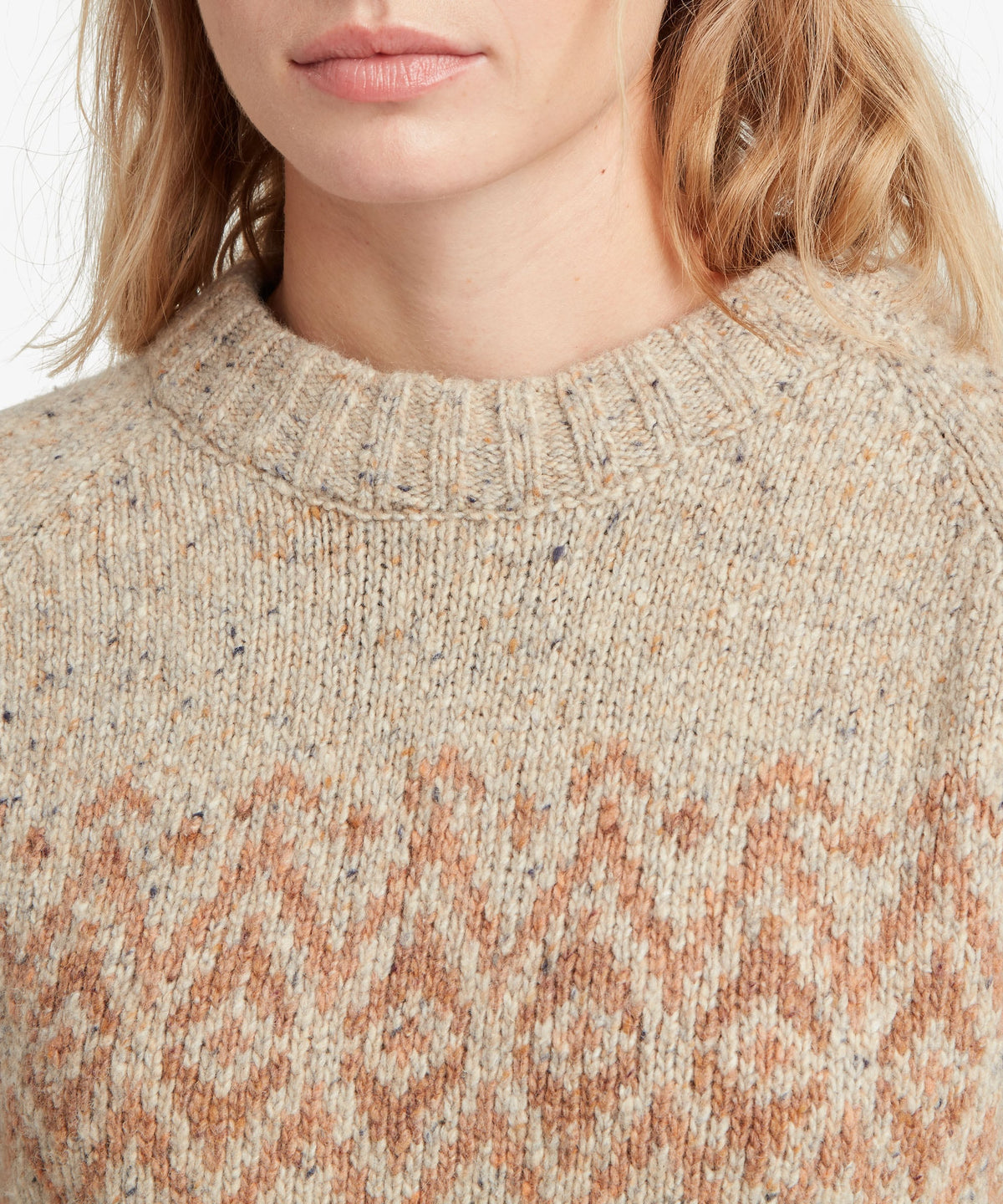 Close-up of woman wearing Sherpa Adventure Gear Dumji Sweater in white and beige.