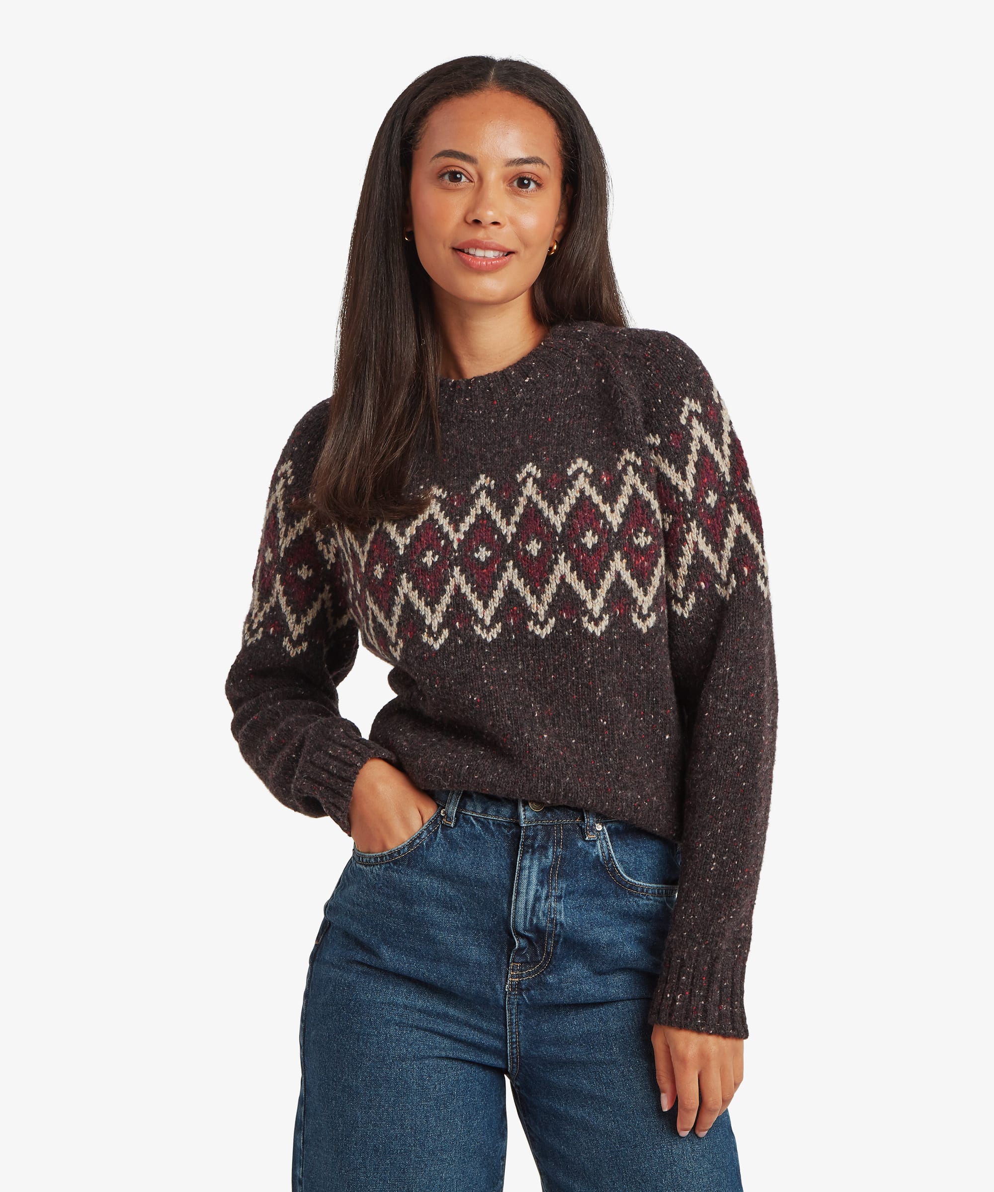 Woman wearing a charcoal-black Fair Isle sweater with burgundy, cream, and grey geometric patterning across the chest and shoulders. Front view showing the crew neckline, long sleeves, and classic fit.