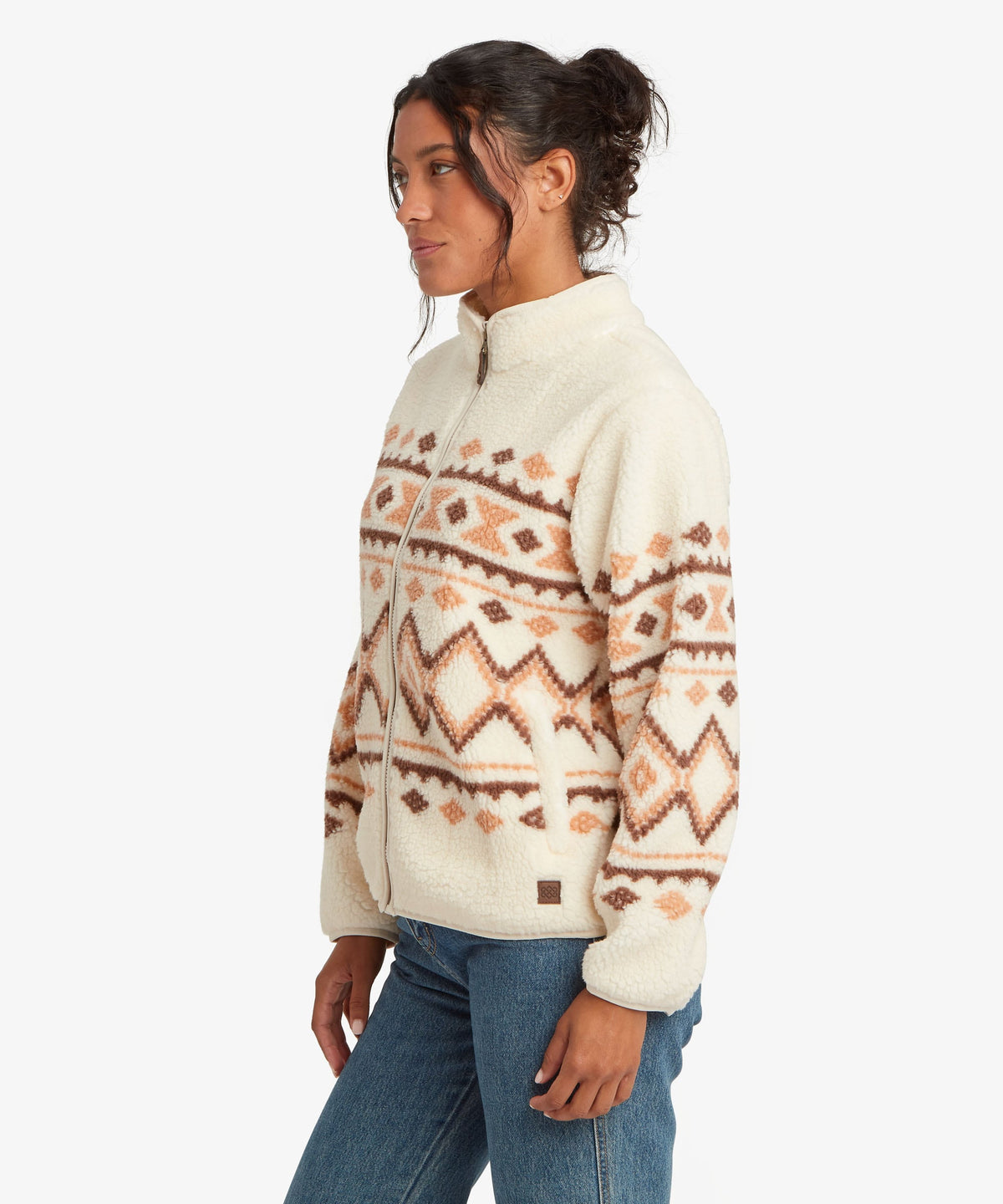 Side view of woman wearing Sherpa Adventure Gear women's Gokyo Jacket in beige.