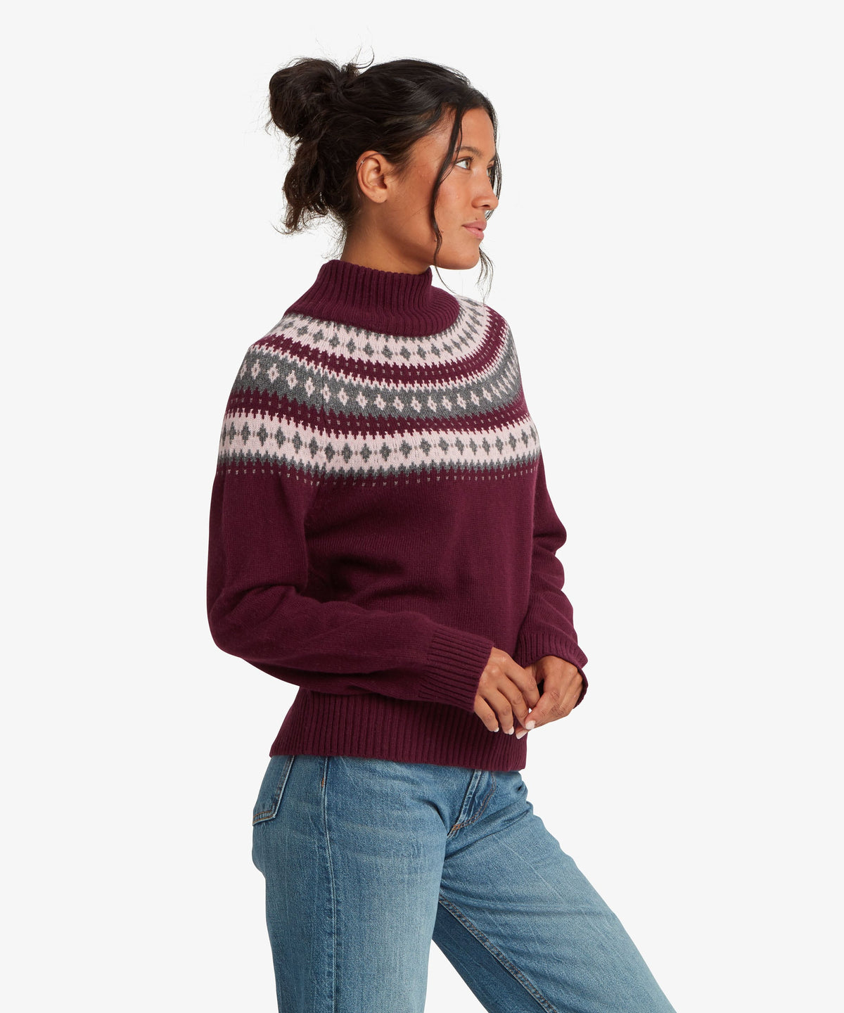 A female model wearing the Sherpa Adventure Gear womenÕs Indu Mock Neck sweater in purple.