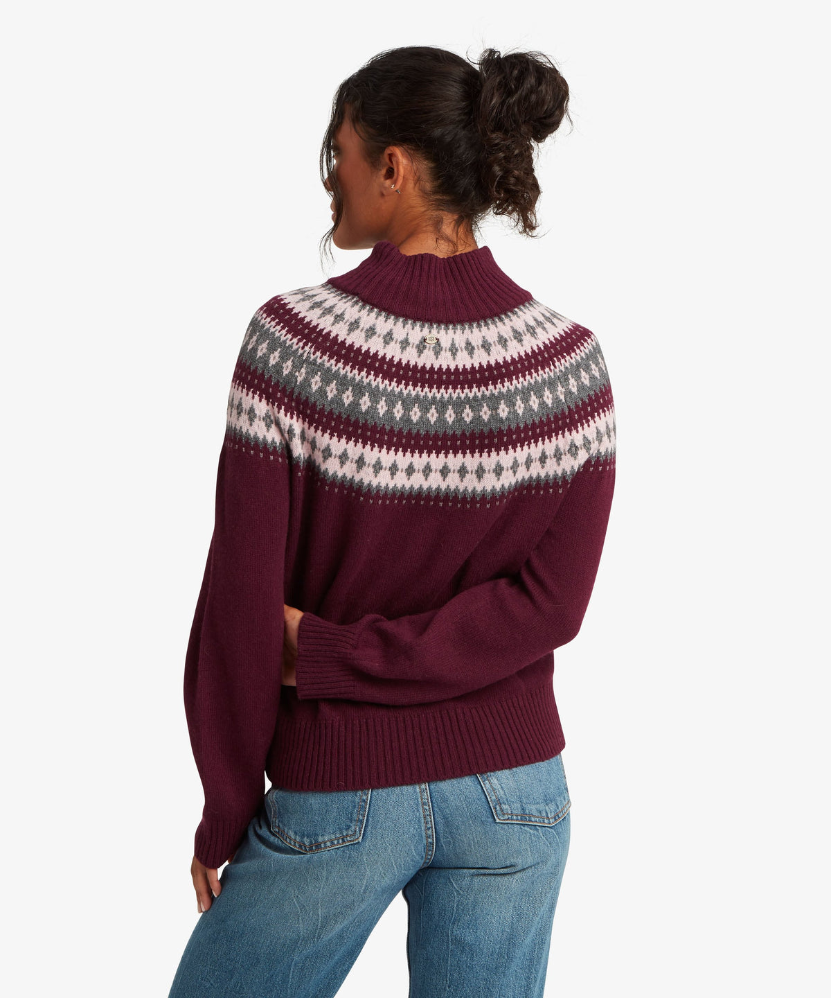 A female model wearing the Sherpa Adventure Gear womenÕs Indu Mock Neck sweater in purple.