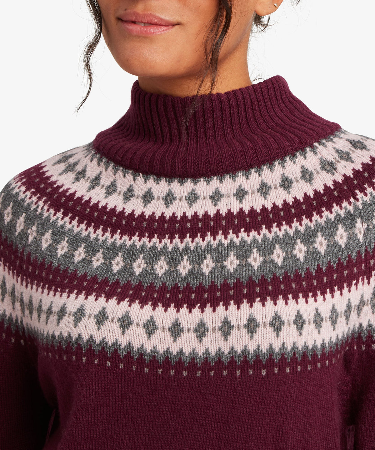 A female model wearing the Sherpa Adventure Gear womenÕs Indu Mock Neck sweater in purple.