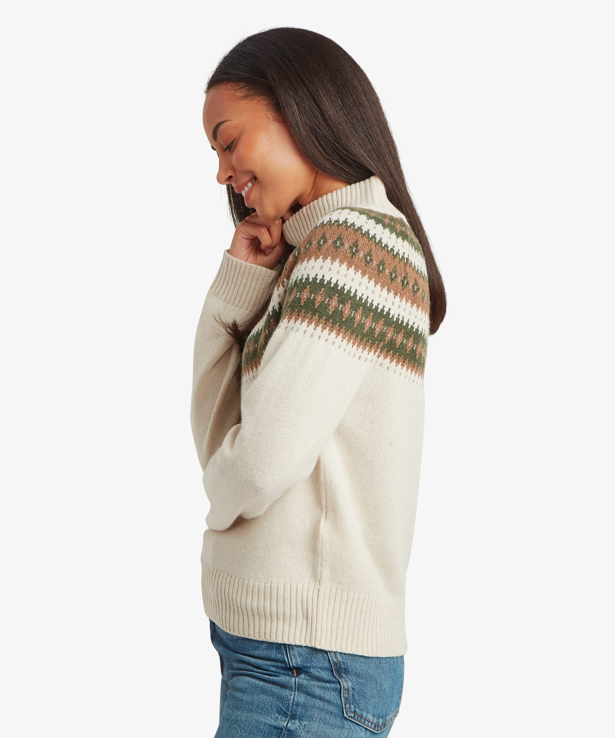 Side-profile view of a woman wearing a cream Fair Isle mock-neck sweater. The image highlights the patterned yoke wrapping around the shoulders, the ribbed mock neckline, and the relaxed silhouette.
