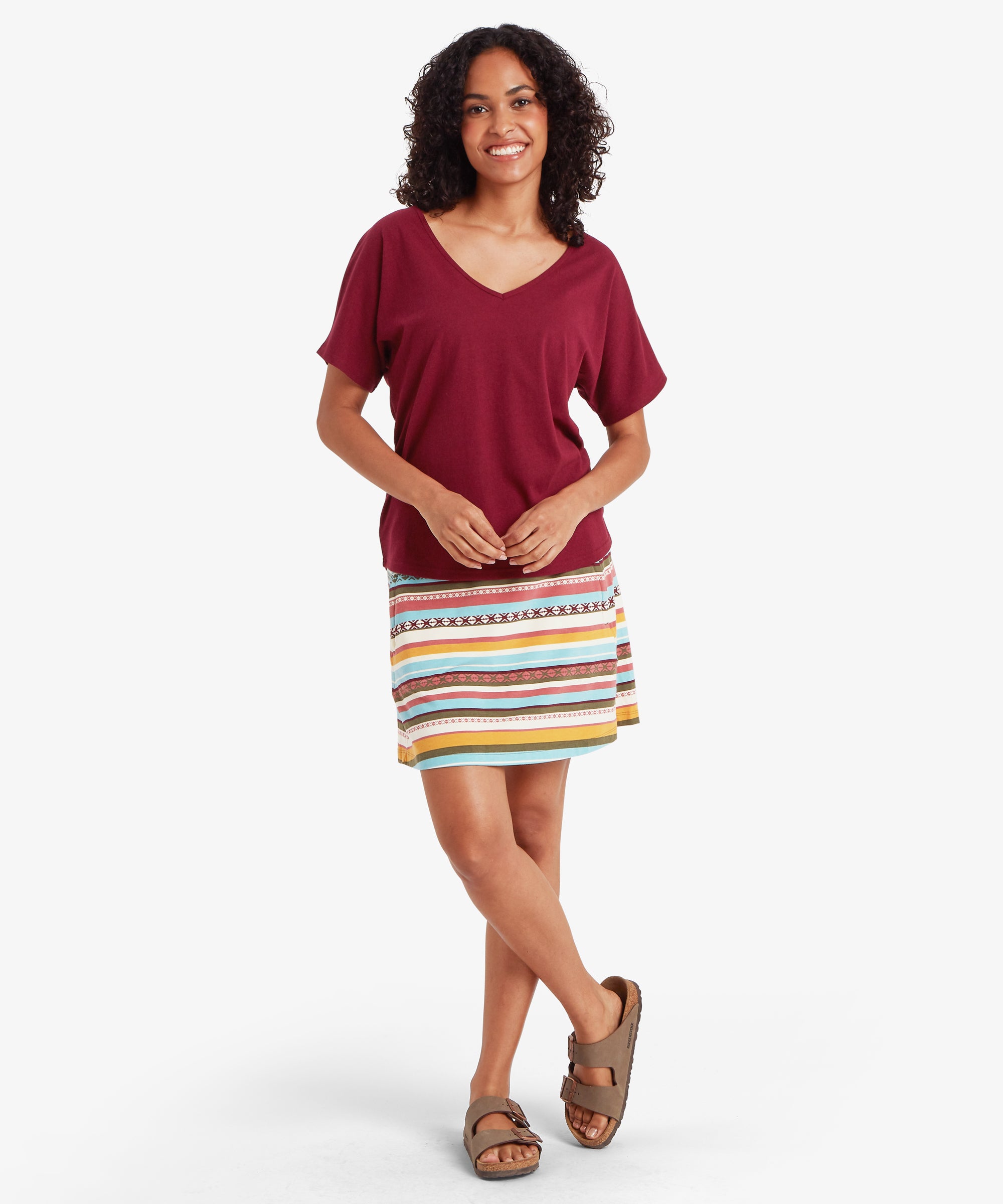 Woman in Jutnu V-Neck T-Shirt Wine with colorful striped skirt