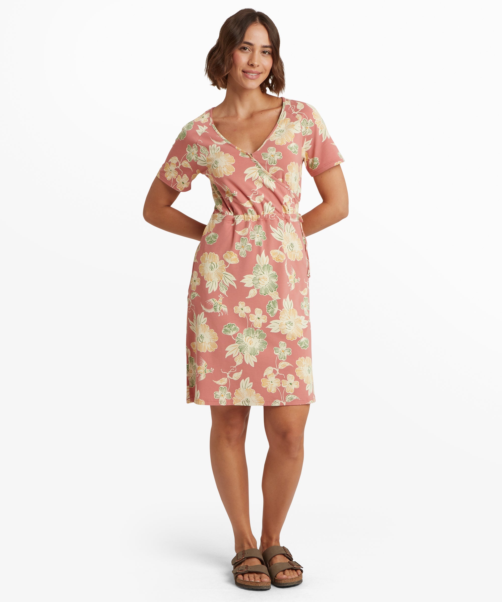 Full front view of a sleeveless pink dress with a relaxed mid‑length silhouette and tonal scenic print. Styled with sandals.