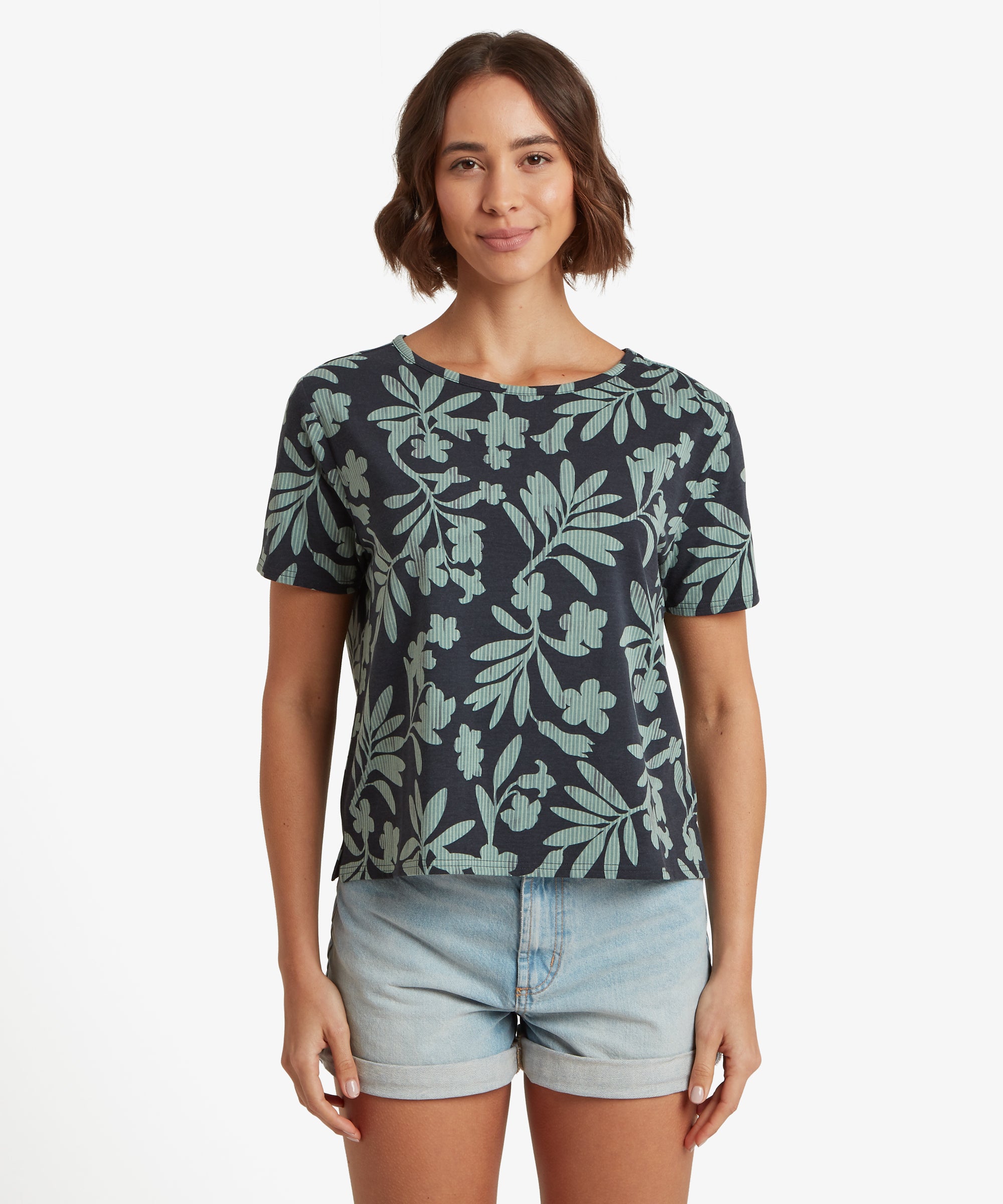 Vorderansicht eines marineblauen T-Shirts mit botanischem Print, kurzen €rmeln und einer kastenfšrmigen, lockeren Passform, getragen zu hellblauen Denim-Shorts mit umgeschlagenem Saum.