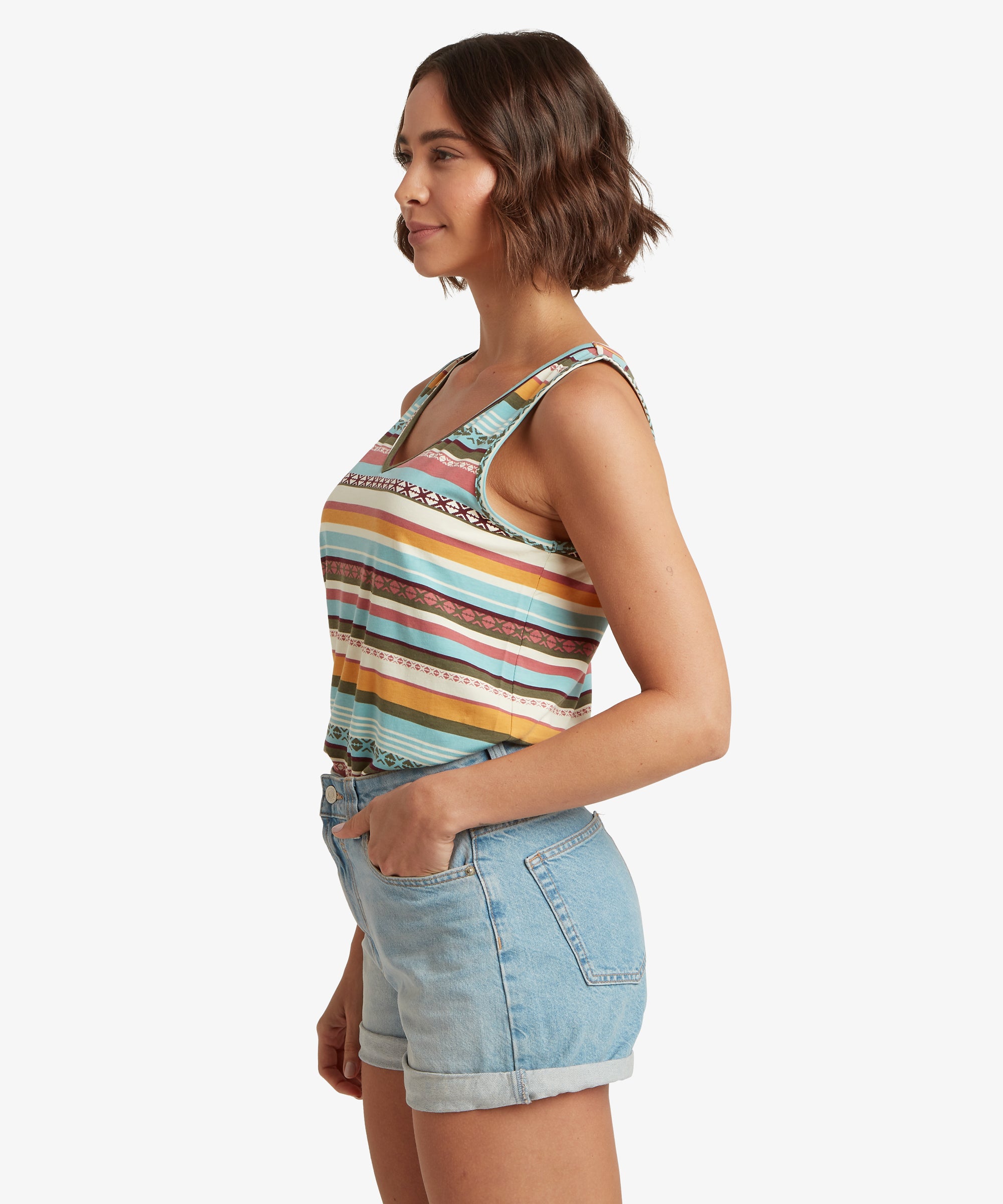 Side view of a patterned striped V‑neck tank top paired with light‑wash denim shorts, highlighting the curved armhole and lightweight fabric.