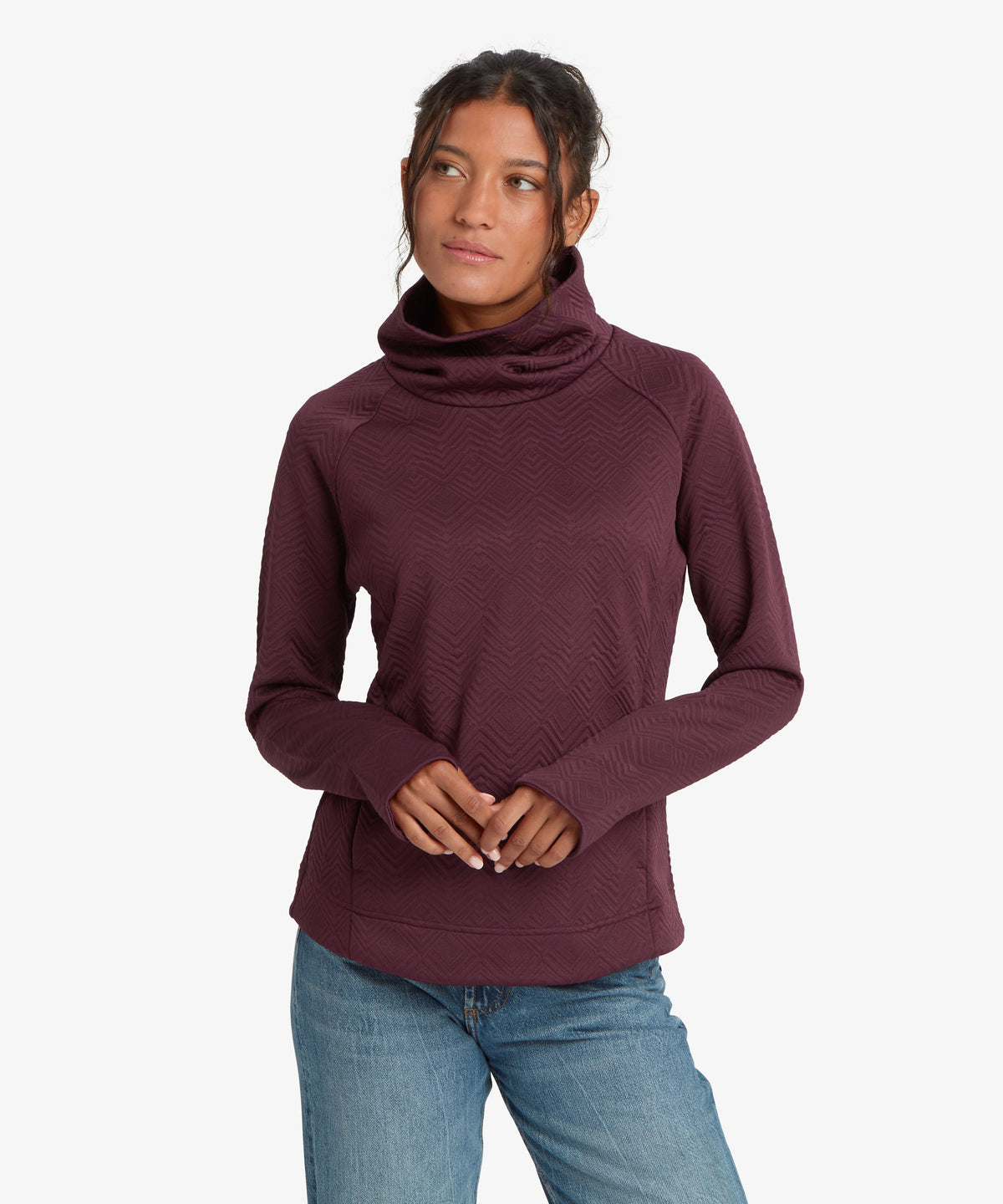 A woman wearing a  long-sleeve cowl neck sweater in a deep burgundy color/