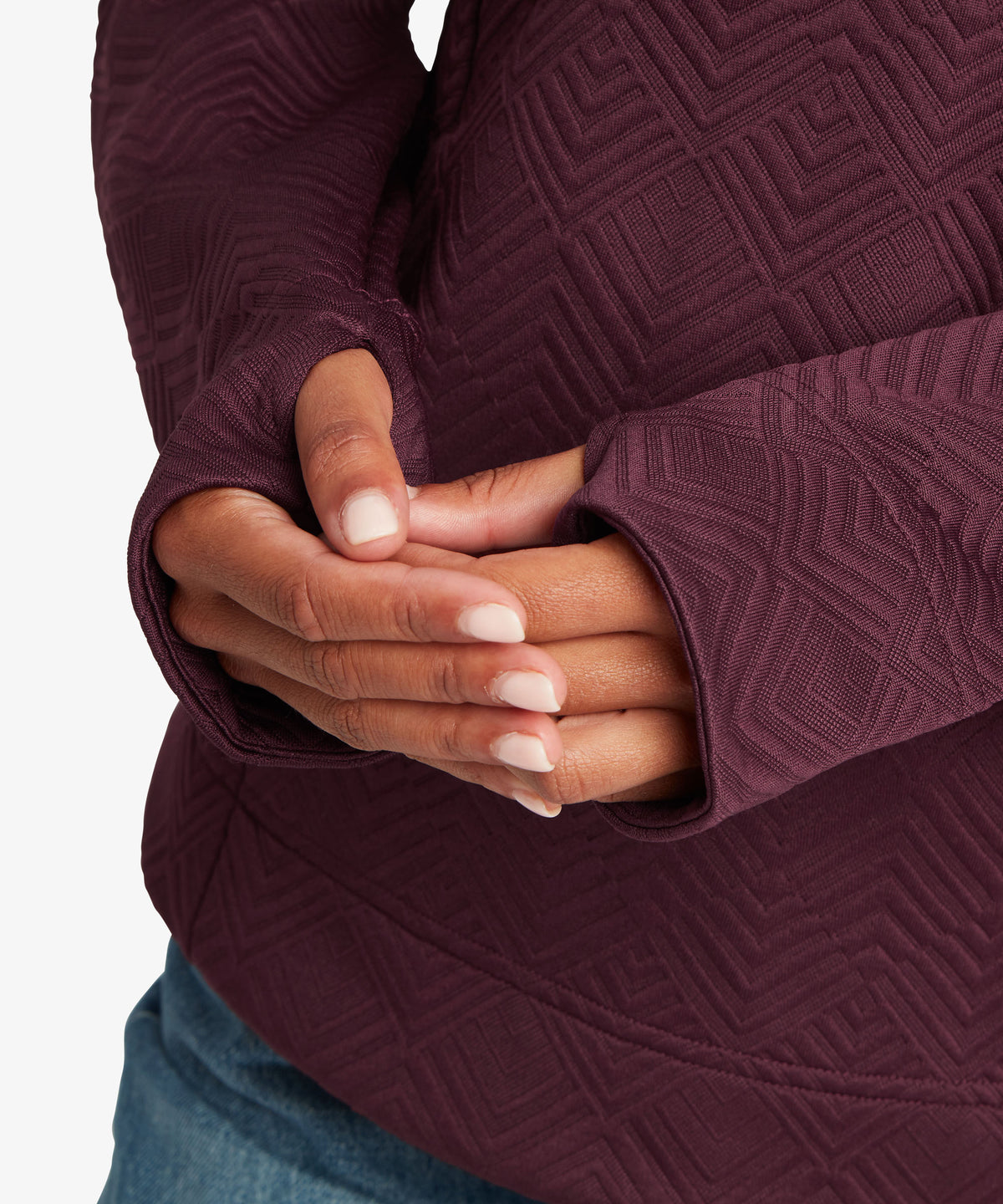 Close-up of a woman wearing a textured plum-purple long-sleeve top.