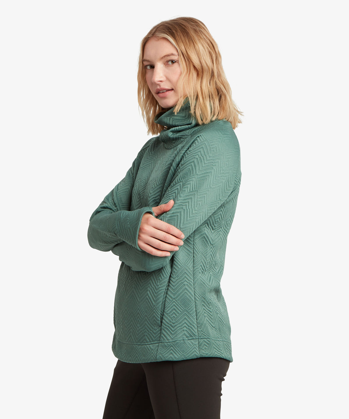 A woman modeling a green textured cowl-neck sweater against a plain white background.