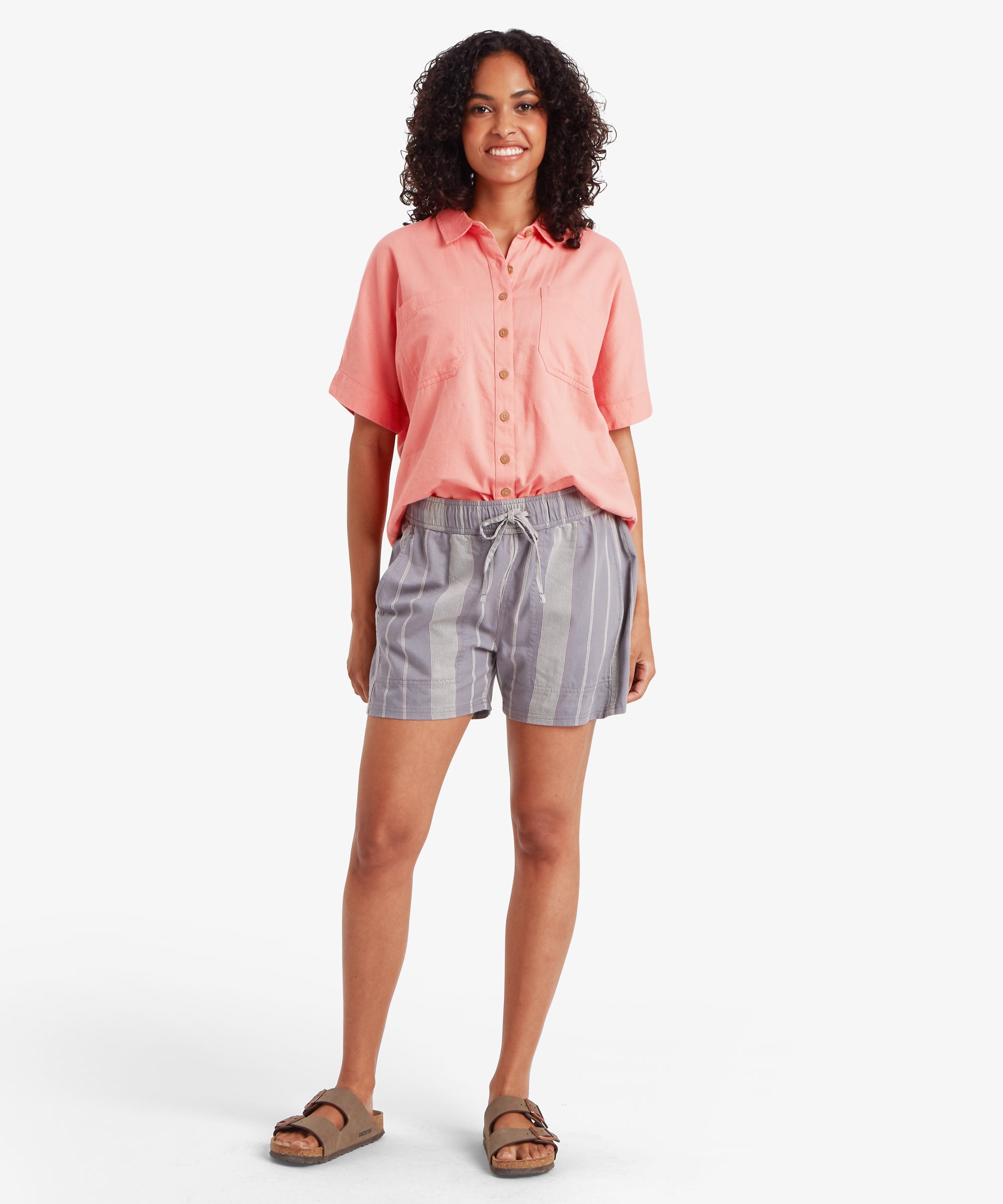 Woman in coral button-up shirt and Palmo Stormy Stripe shorts