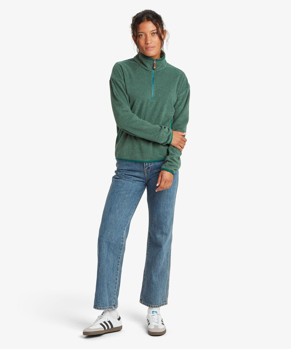 A female model wearing the Sherpa Adventure Gear womenÕs Rolpa 1/2 Zip in green.