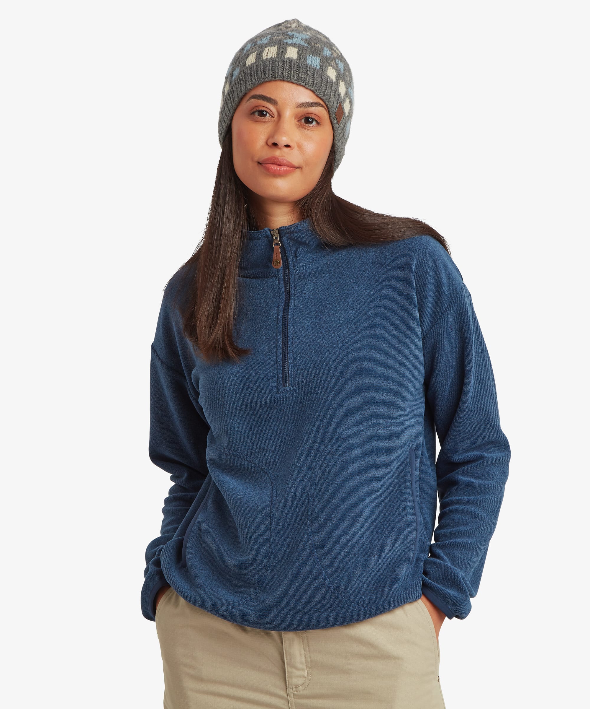 Woman wearing a blue fleece pullover with a half-zip neckline and stand collar. Front view showing the soft textured fleece fabric, relaxed fit, and outdoor-inspired styling paired with a patterned beanie.