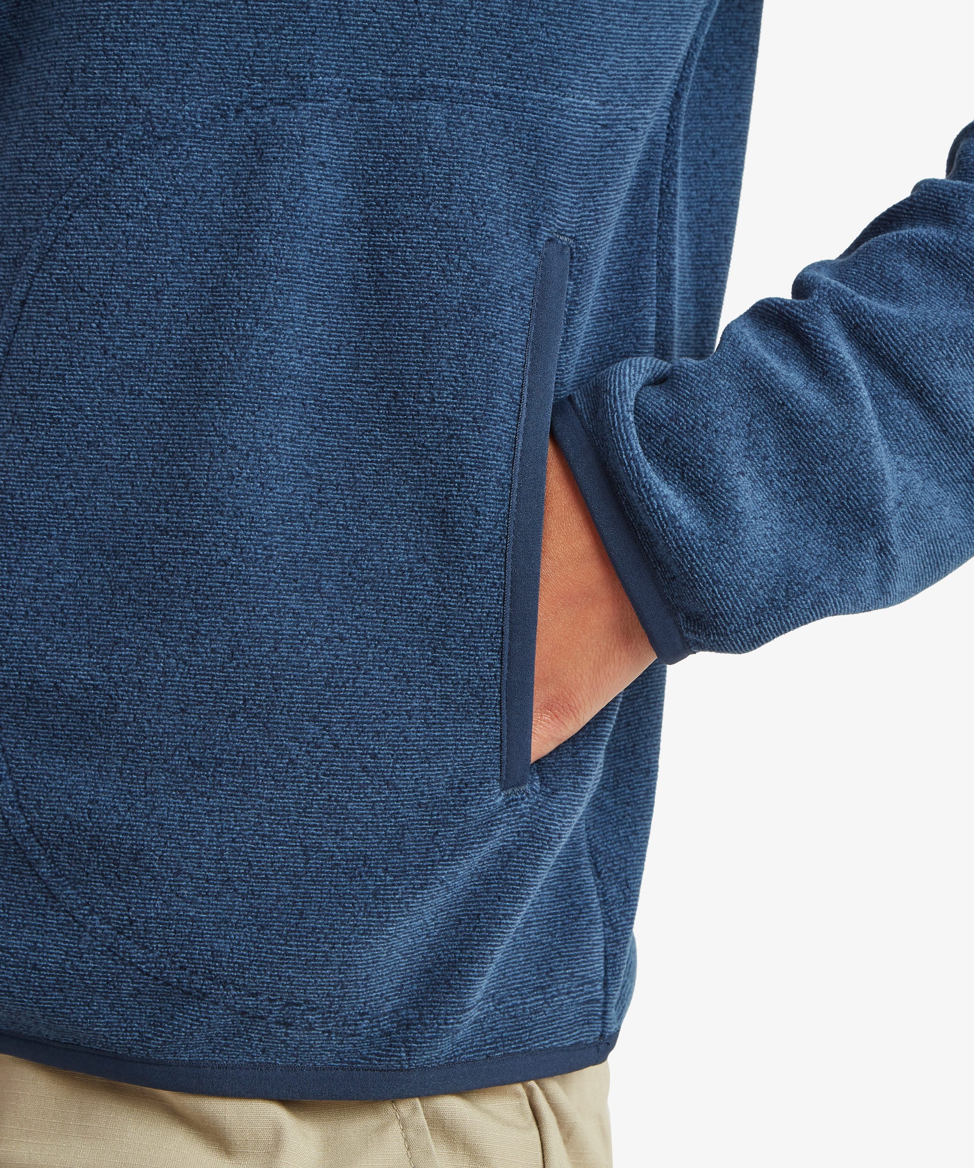 Close-up detail of the Sherpa Rolpa 1/2-Zip Pullover in blue showing the side hand pocket and soft fleece fabric construction.