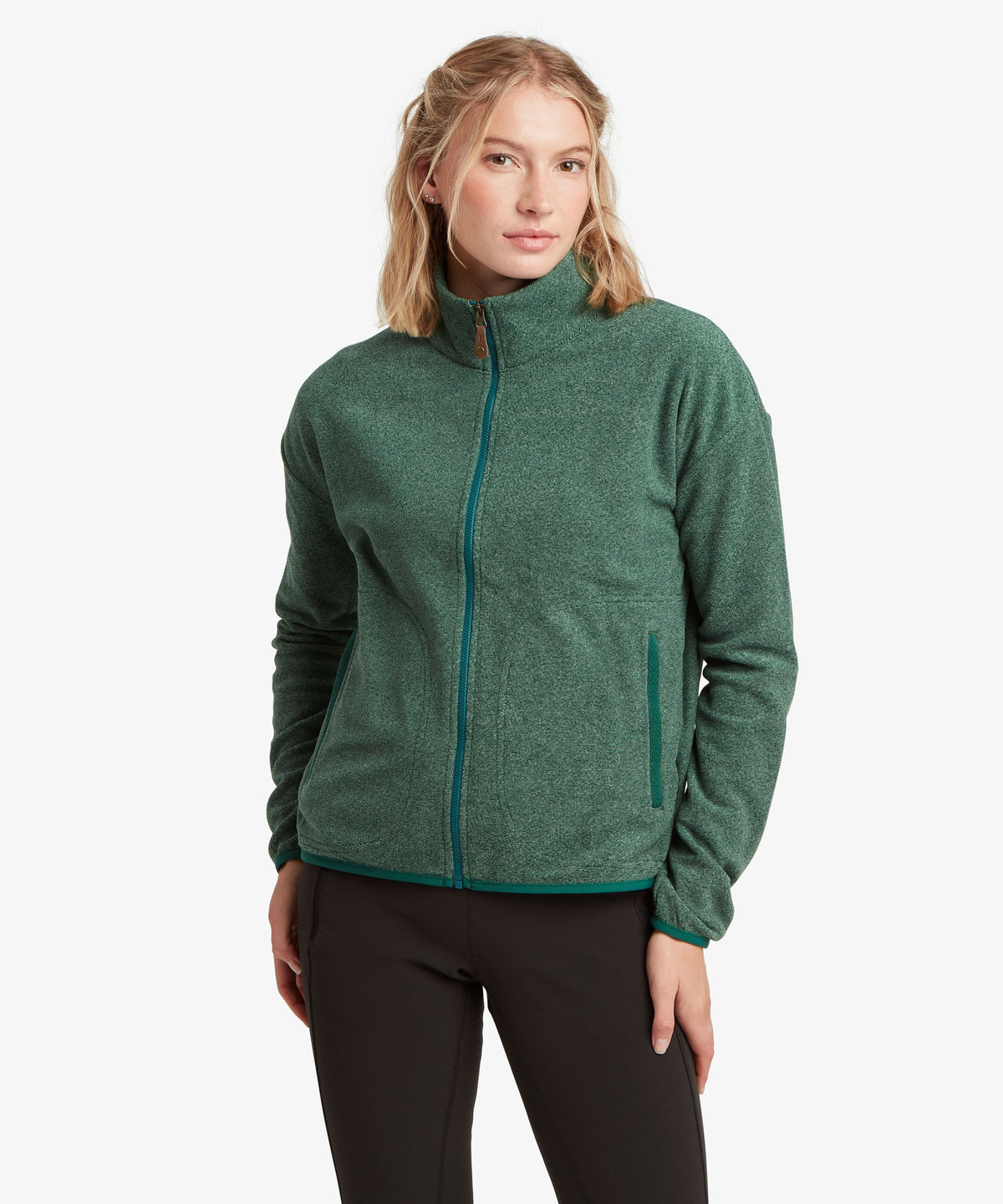 A female model wearing the Sherpa Adventure Gear Rolpa Full Zip fleece in green.