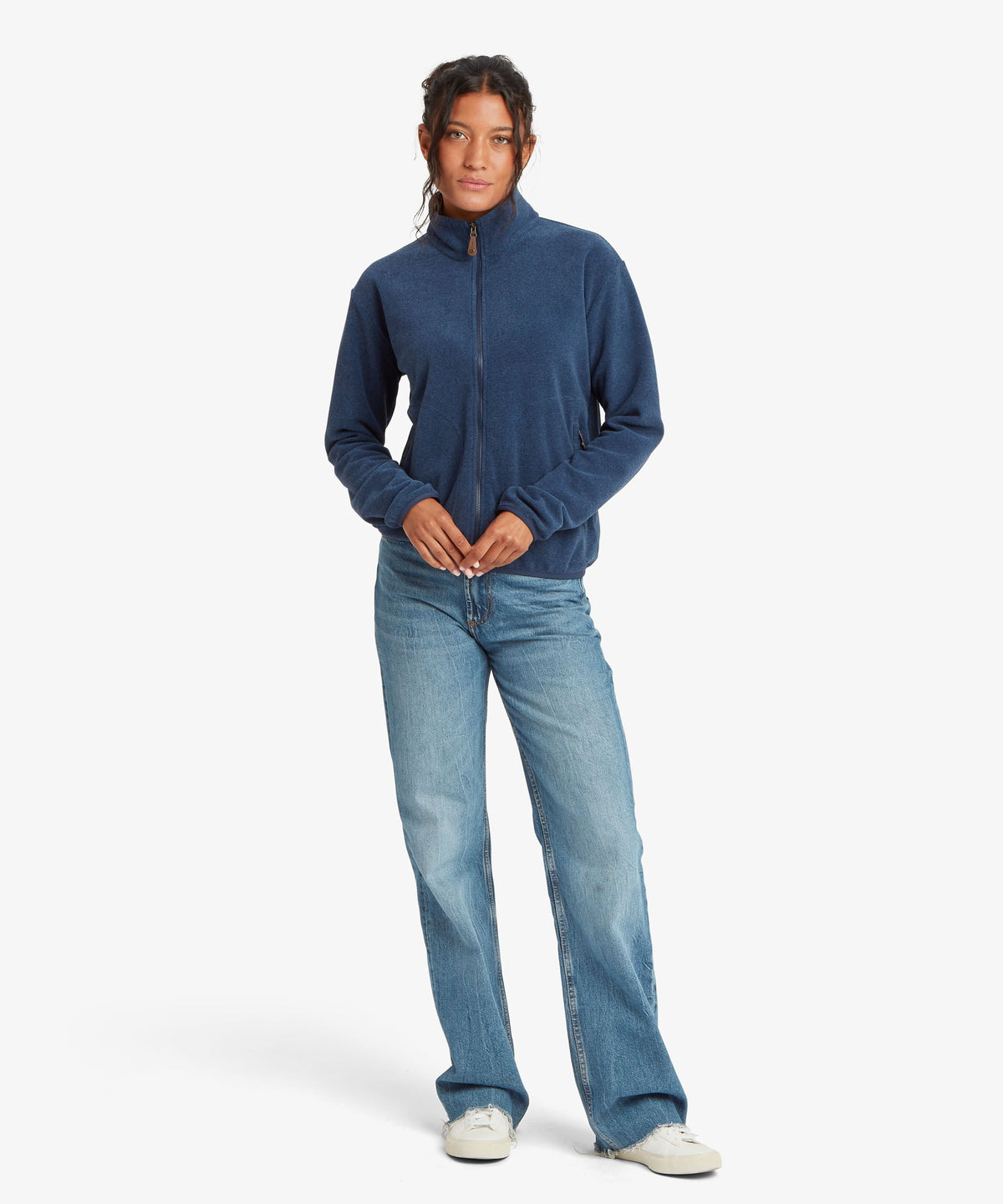 A female model wearing the Sherpa Adventure Gear Rolpa Full Zip fleece in navy.
