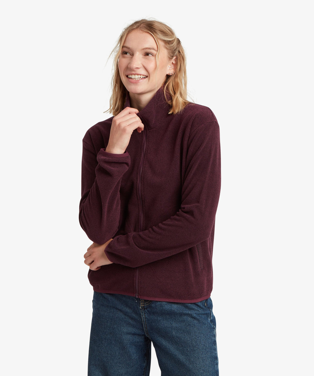 A female model wearing the Sherpa Adventure Gear Rolpa Full Zip fleece in purple.