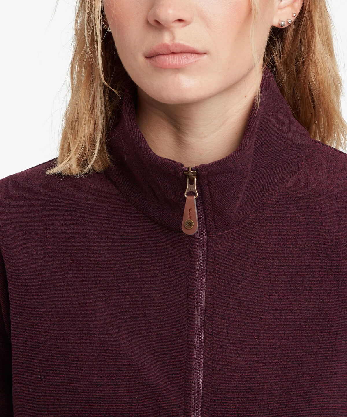 A female model wearing the Sherpa Adventure Gear purple Rolpa Full-Zip fleece.