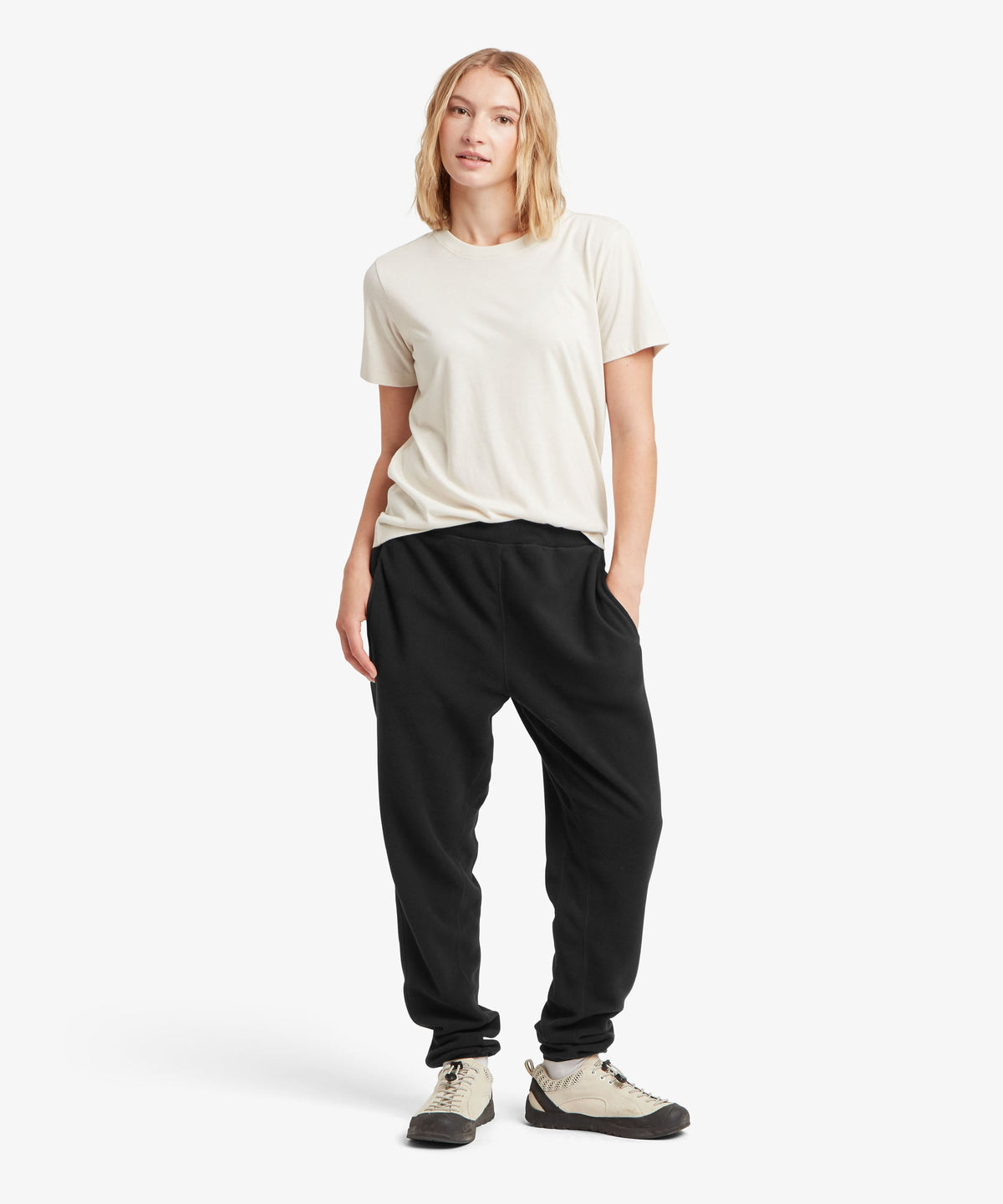 A female model wearing the Sherpa Adventure Gear black Rolpa Jogger trousers with a white T-shirt.