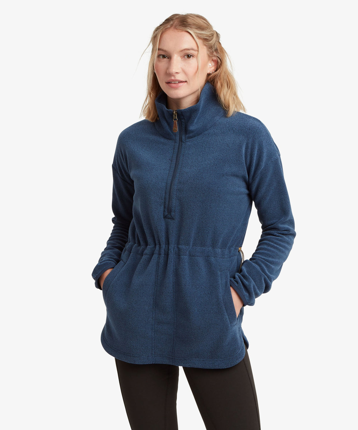 A female model wearing the Sherpa Adventure Gear navy Rolpa Pop-Over fleece with black leggings.