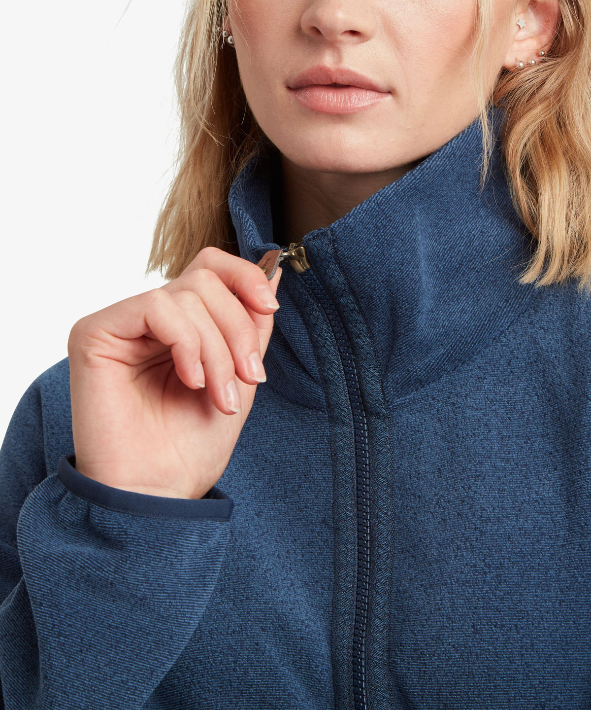 A female model wearing the Sherpa Adventure Gear navy Rolpa Pop-Over fleece, shown in close-up.