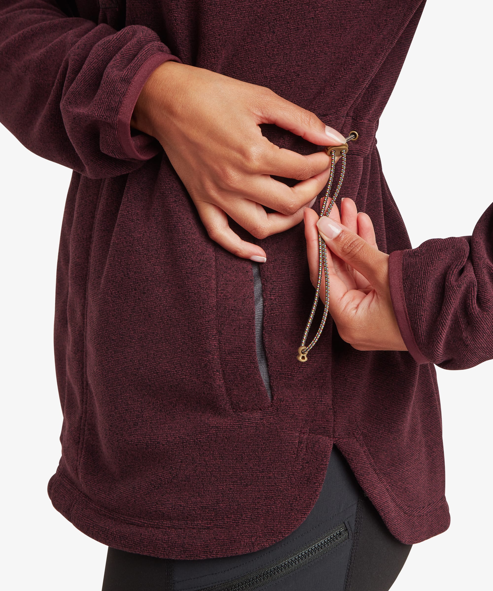 Close-up detail of the burgundy Sherpa Rolpa Pop Over fleece showing the concealed side pocket with the zipper partially opened. The image highlights the pocket construction and textured fleece fabric.